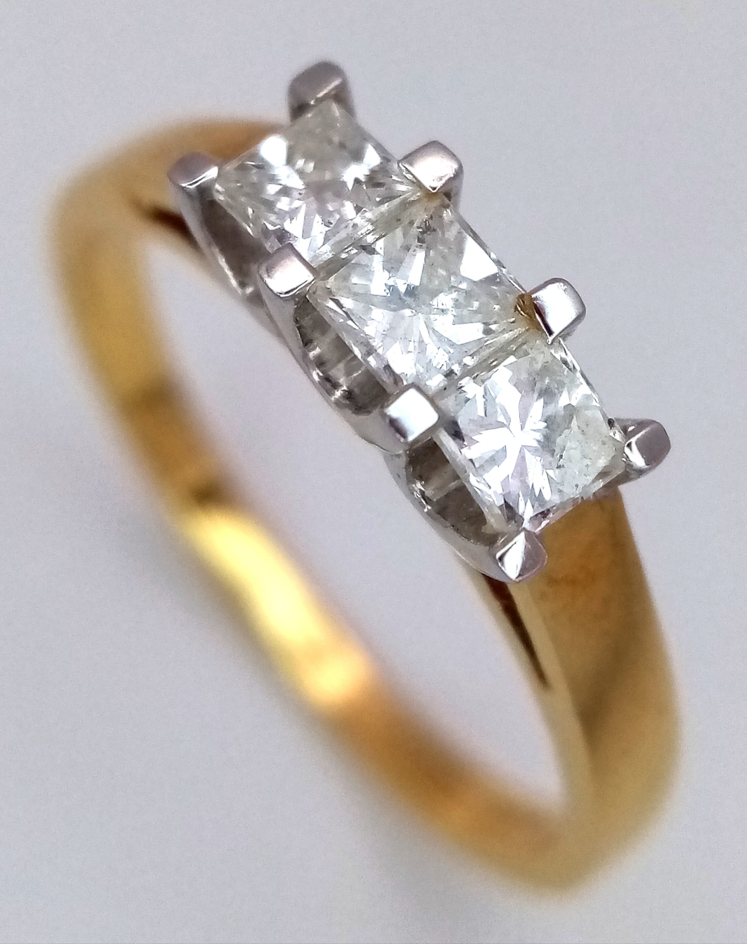 An 18K Yellow Gold Diamond Trilogy Ring. Three Princess cut diamonds - 0.50ctw having F-G colour with VS2 clarity. Size M. 2.92g total weight.