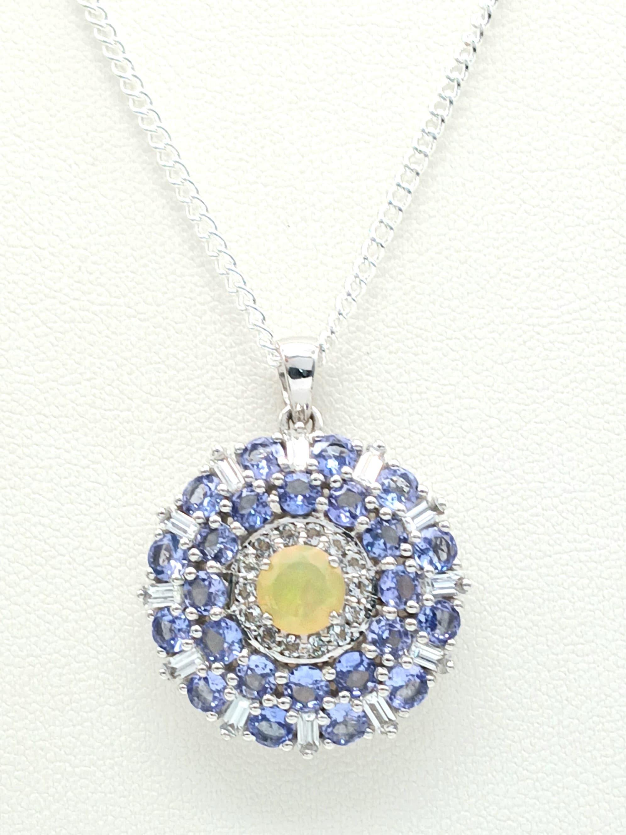 A Beautiful Sterling Silver Hand Crafted Tanzanite, Opal and White TopazPendant Necklace. 46cm Length chain. The Pendant measures a 2.8cm dropfrom the chain and is 2.4cm Wide. Gross weight 8.82 grams