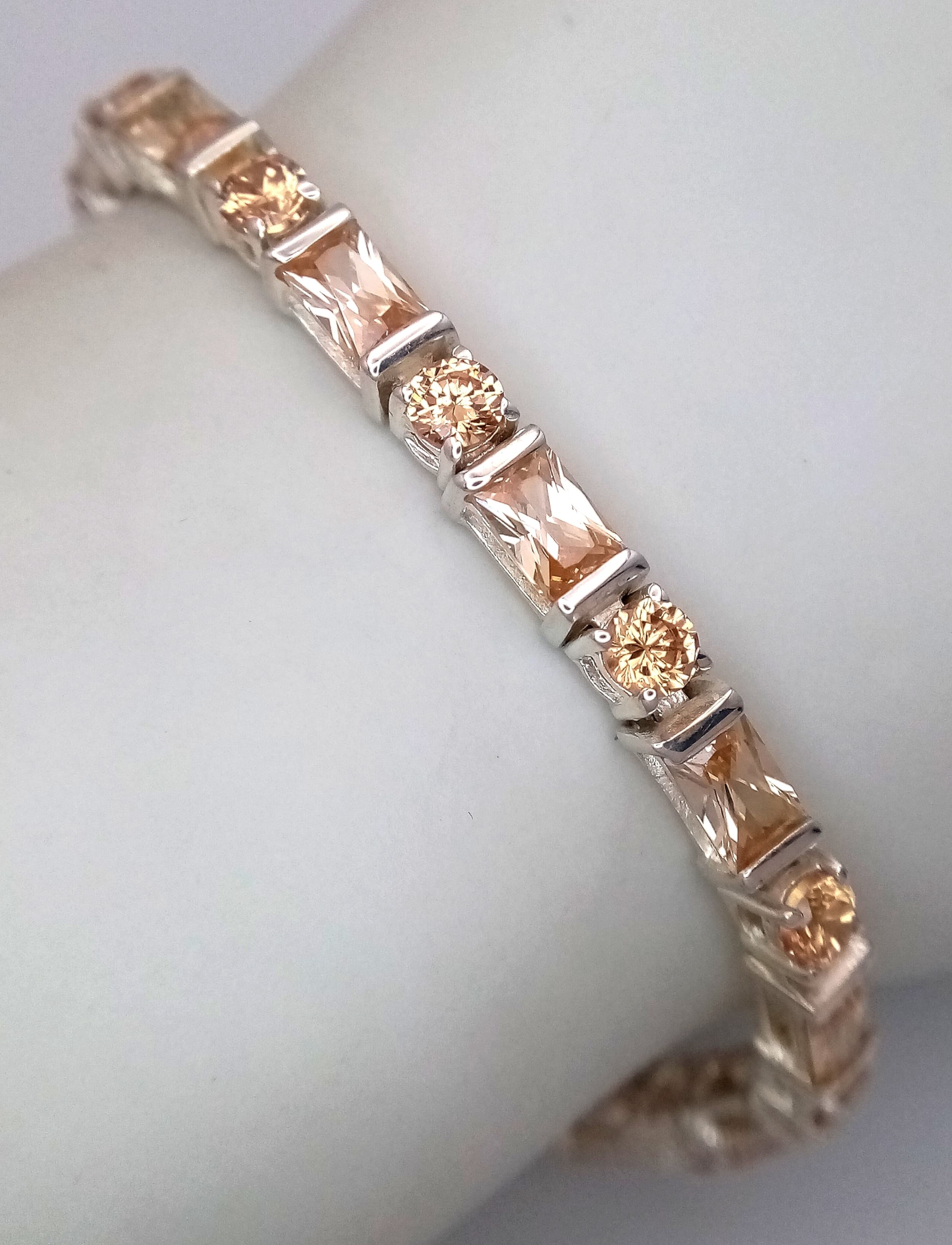 A Stylish Sterling Silver Citrine Set Tennis Bracelet-Fits 18 to 21cm Length. Set with Twenty-six Round and Rectangle Cut Citrine, approximately 8.45 carat total. 14.87 grams.