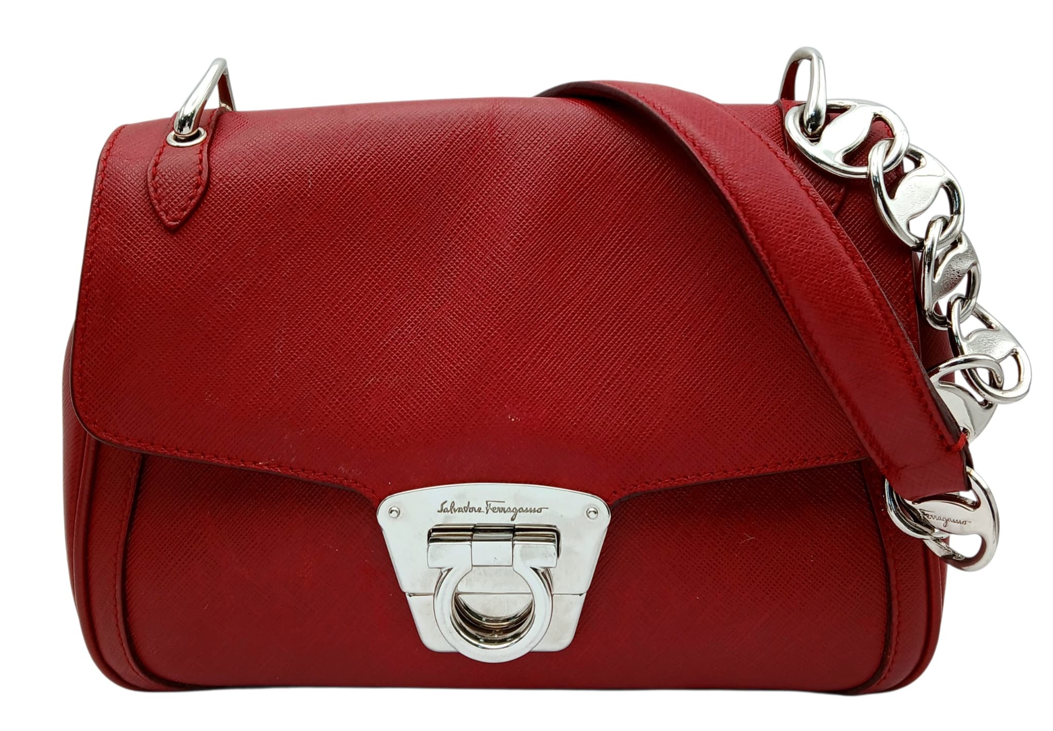 A Salvatore Ferragamo Red Leather Shoulder Bag. Red leather exterior with silver-tone hardware, chain and leather shoulder straps, and front flap with Gancini turn-lock closure. Purple jacquard textile interior with a main compartment and two inner side pocket. Approximately 21cm length x 16cm height. In good overall condition with minor marks to the leather exterior – please see photos or request a condition report. Ref: 27876