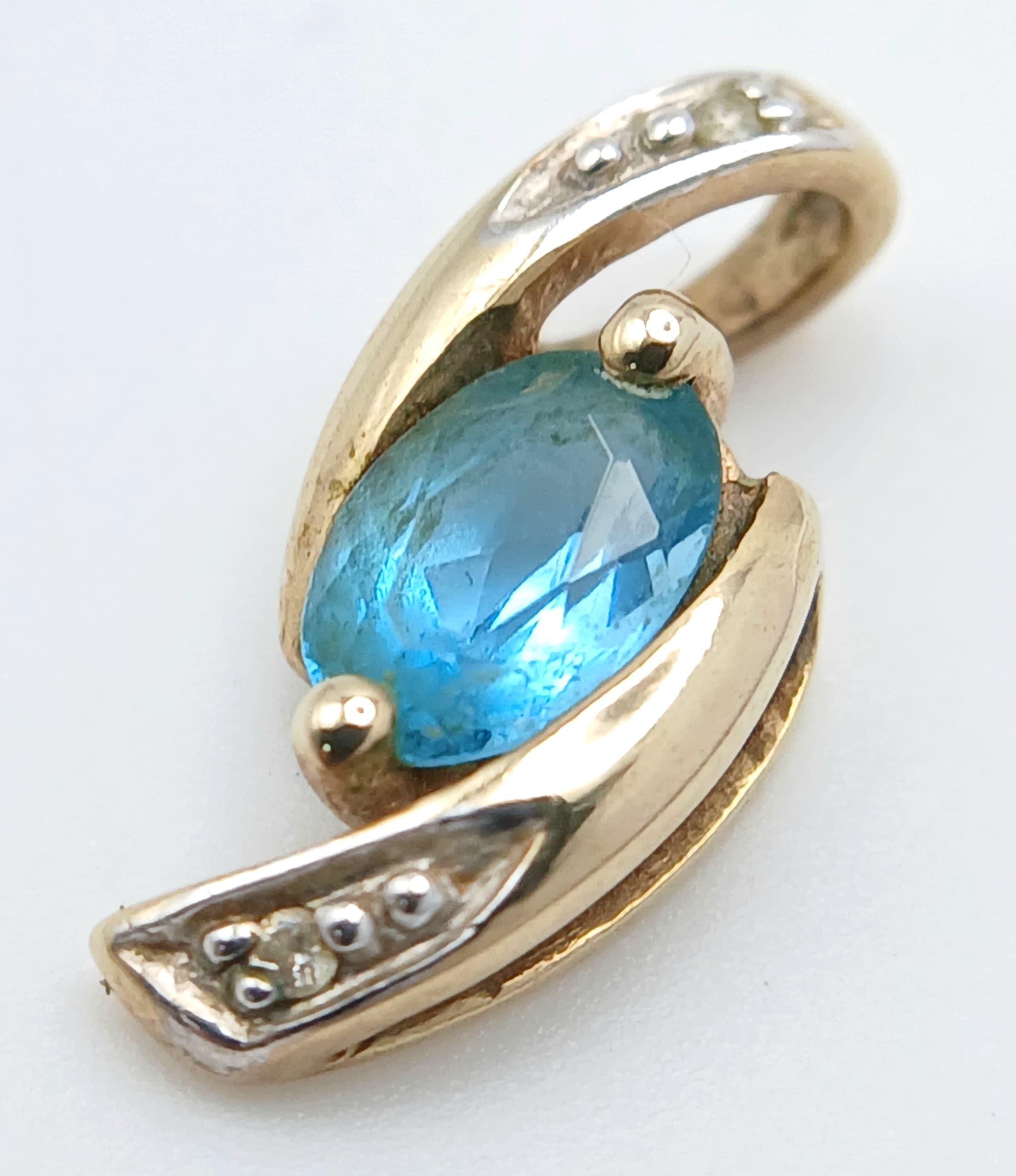 A Pretty 9 Carat Gold Blue Topaz and Cubic Zirconia Pendant.1.3cm Length. Gross weight 0.60 grams.
