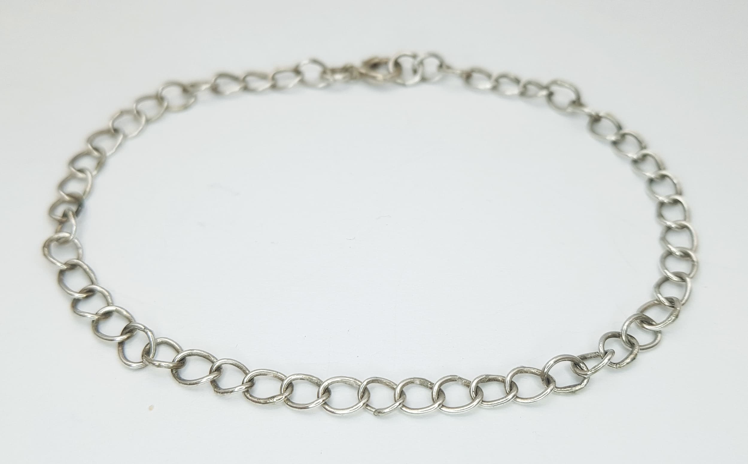 A silver curb link bracelet. Total weight 2.5G, total length 19cm.