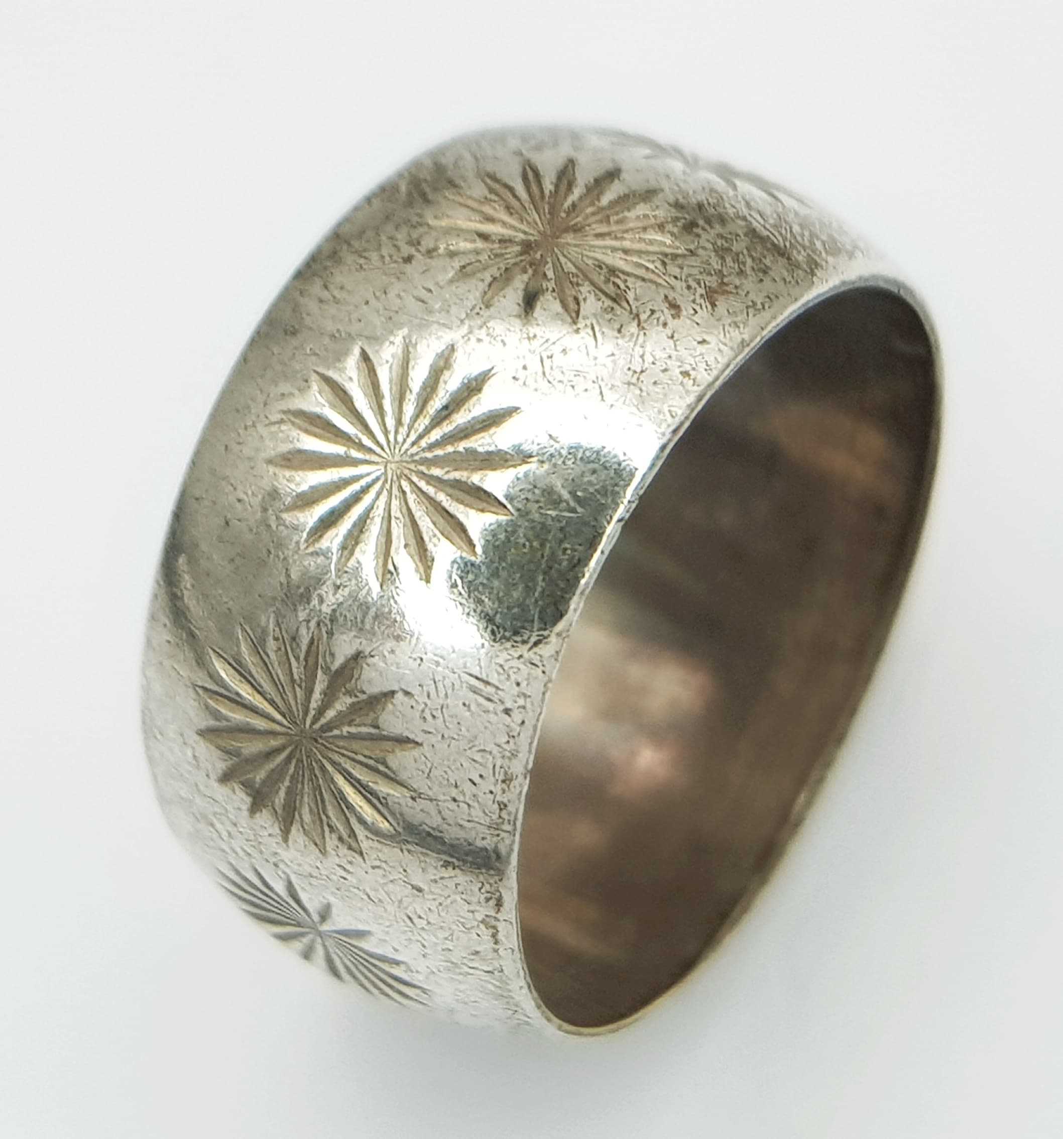 A vintage silver floral motif design band ring. Total weight 6.7G. Size N
