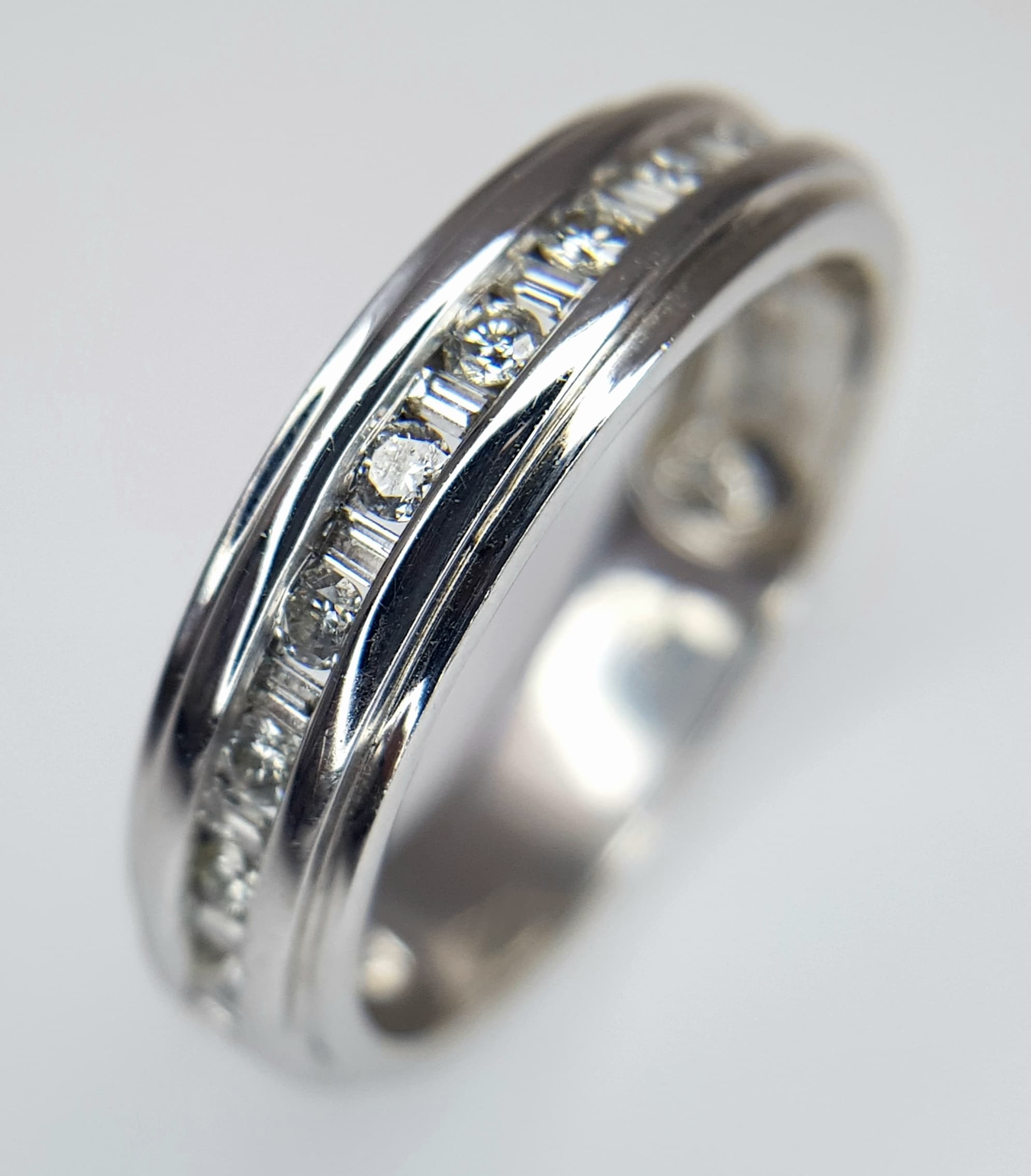 A 14K WHITE GOLD, DIAMOND SET, BAND RING. 0.50 CT WEIGHT. TOTAL WEIGHT 6.5G, SIZE U. SPSA 1040