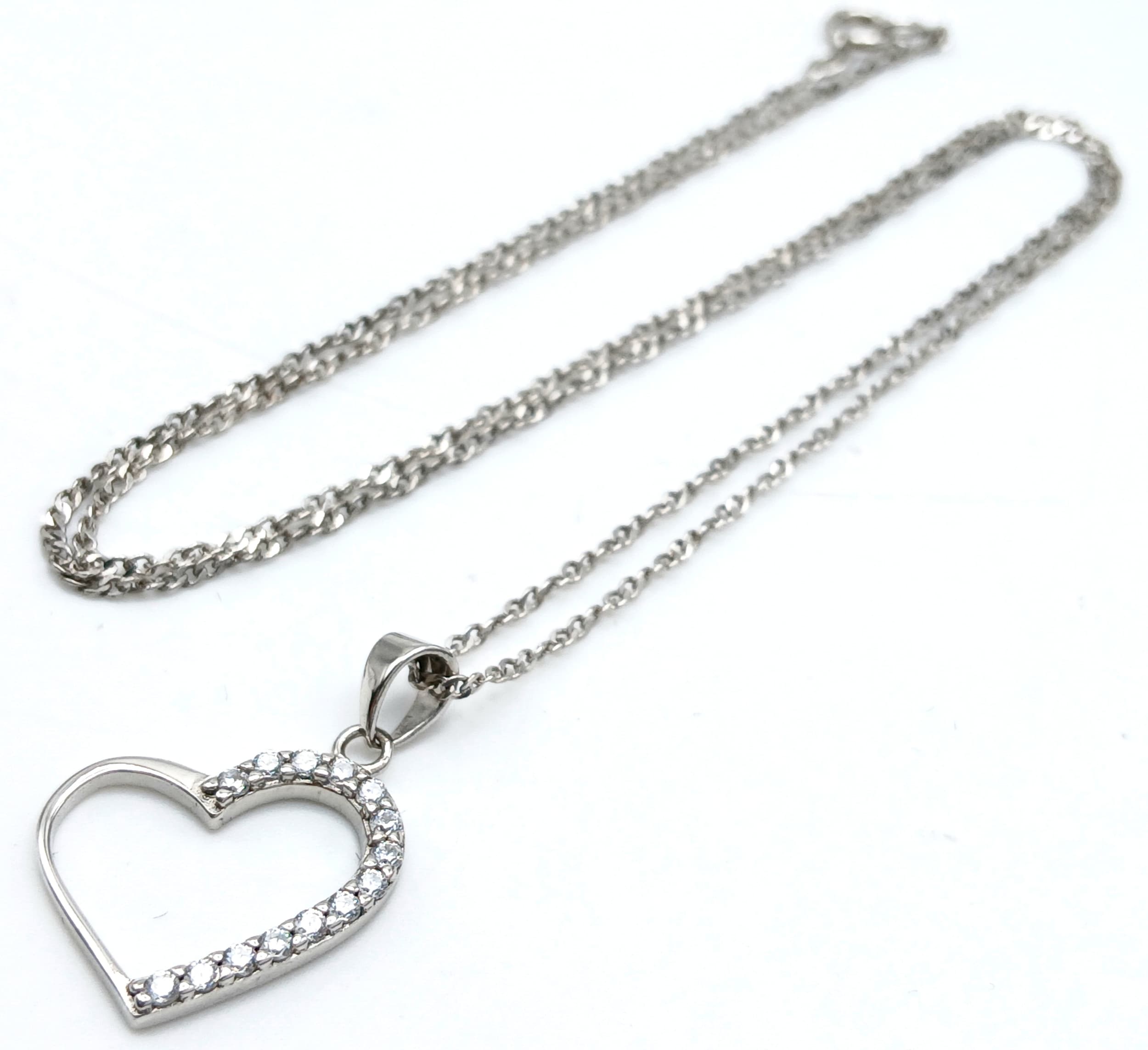 A 925 Silver Necklace with a Stone Set Heart Pendant. Both Necklace and Pendant are Hallmarked 925. Total weight 2.04g. Approx 44cm chain length. Comes with presentation box.