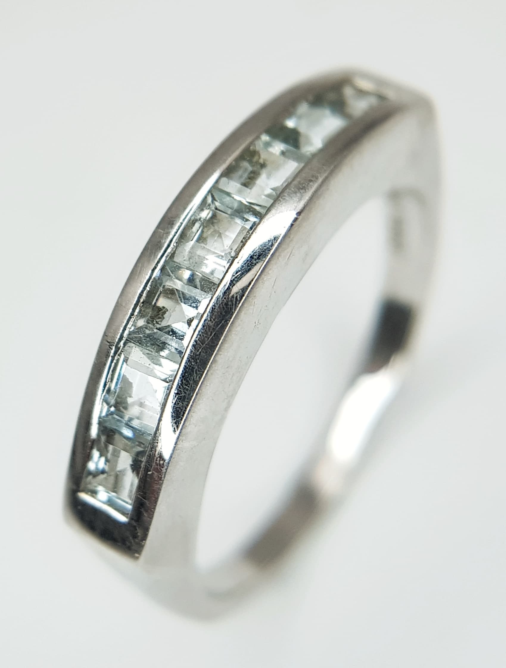A Stylish Sterling Silver and Aquamarine Set Ring Size P1/2. The ring comes with its Certificate of Authenticity. Set with Seven 3mm Square CutAquamarine totalling 0.98 carat. This is a Limited Edition of only 364produced worldwide. Gross weight 3.9 Grams.