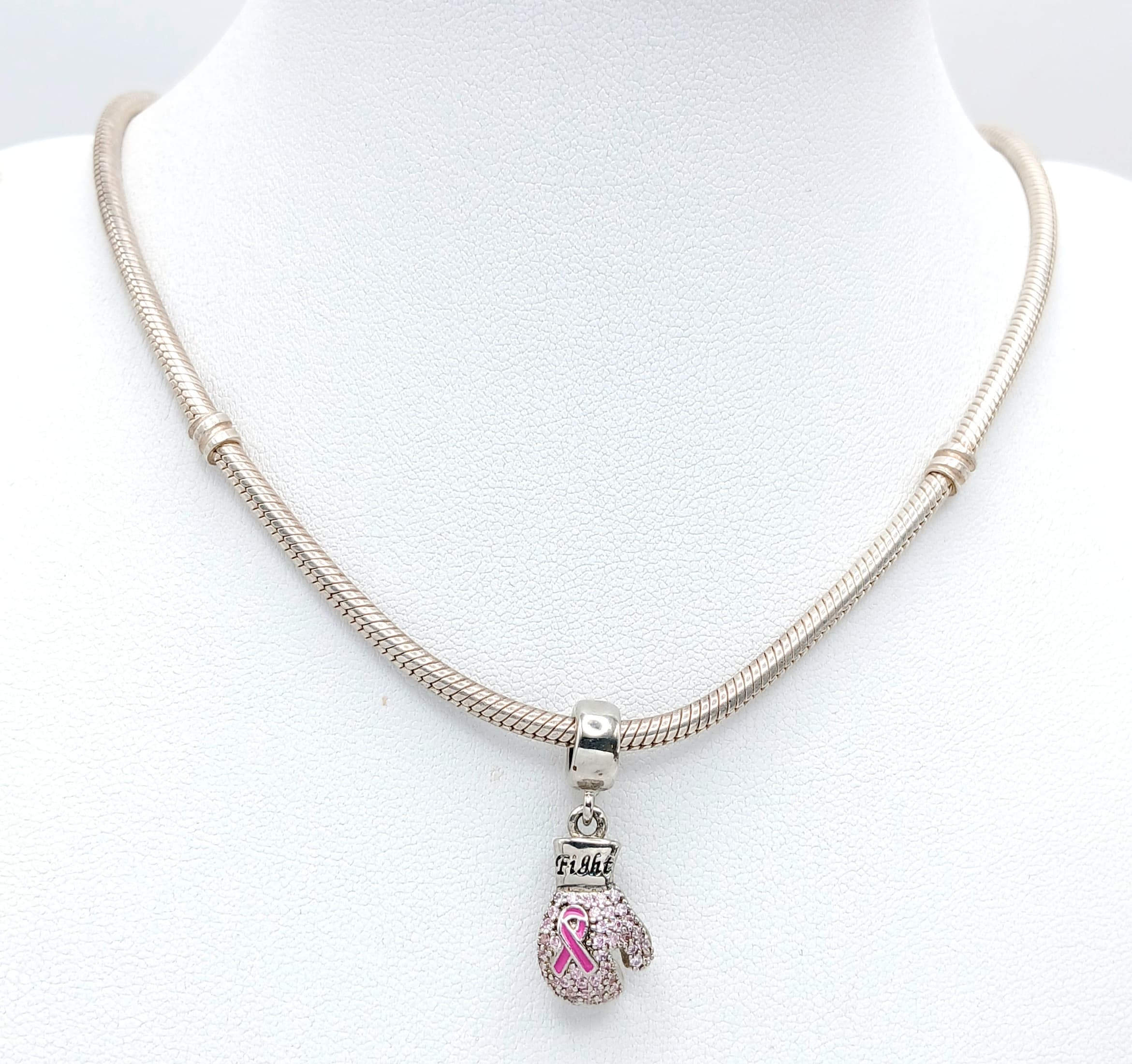 A 925 Sterling Silver Pandora Necklace. A pink ribbon and pink stone-set boxing glove charm. Total chain length: 42.2cm. Charm approx: 2.6cm x 1cm. Total weight: 31.5g.