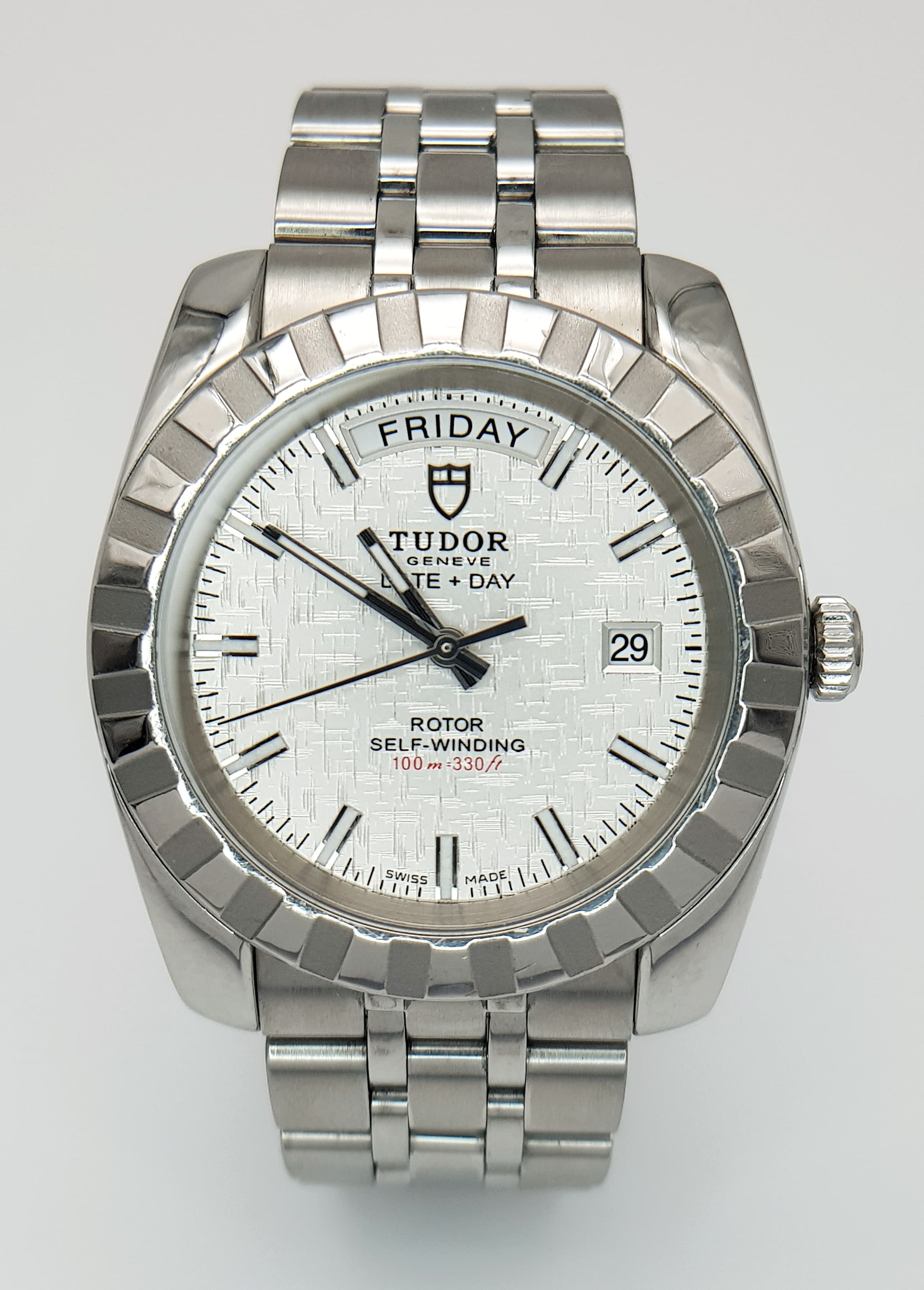 A Classic Tudor Day-Date Automatic Gents Watch. Stainless steel bracelet and case - 41mm. Cut groove and polished bezel. Silver tone linen dial with date and day window. In good condition and working order.