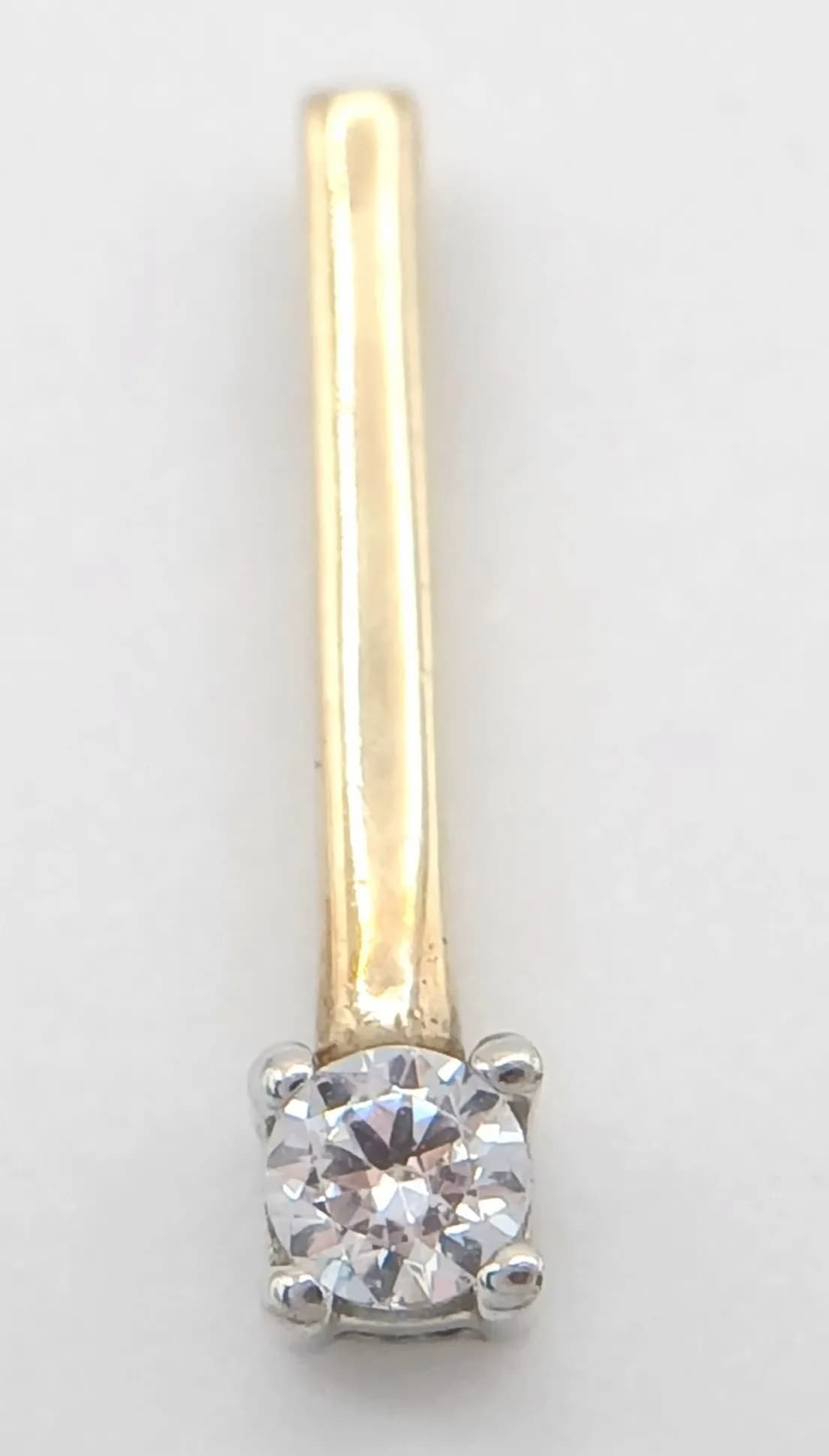 A Vibrant 9k Yellow Gold (Tests as) Cubic Zirconia Solitaire Bar Pendant. 1.5cm Length. Set with a 3mm vibrant quality Cubic Zirconia. Gross weight 0.45 grams.
