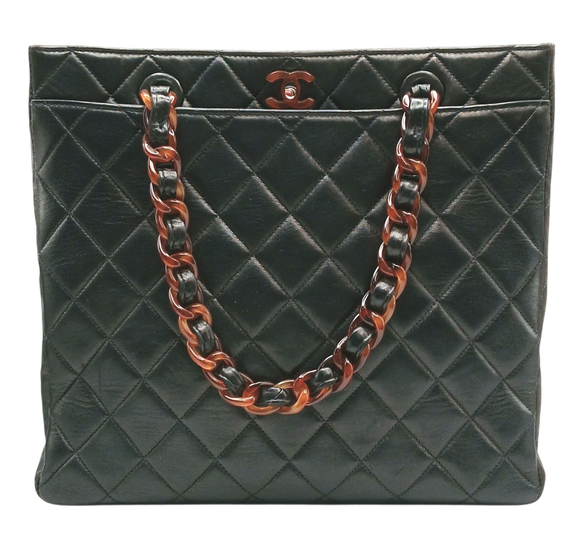 A Chanel Black Quilted Leather Tote Bag. Black diamond-quilted leather exterior with brown tortoiseshell-effect and attachable chain shoulder straps, open top with twist lock closure. Black textile interior with one main compartments, two zipped pocket and an open side pocket. Approx 29cm length x 26cm height x 9cm depth. Some scratches, signs of wear and tear to the leather. Comes with a certificate of authenticity and dust cover. Please see photos or request a condition report. Ref: 28709.