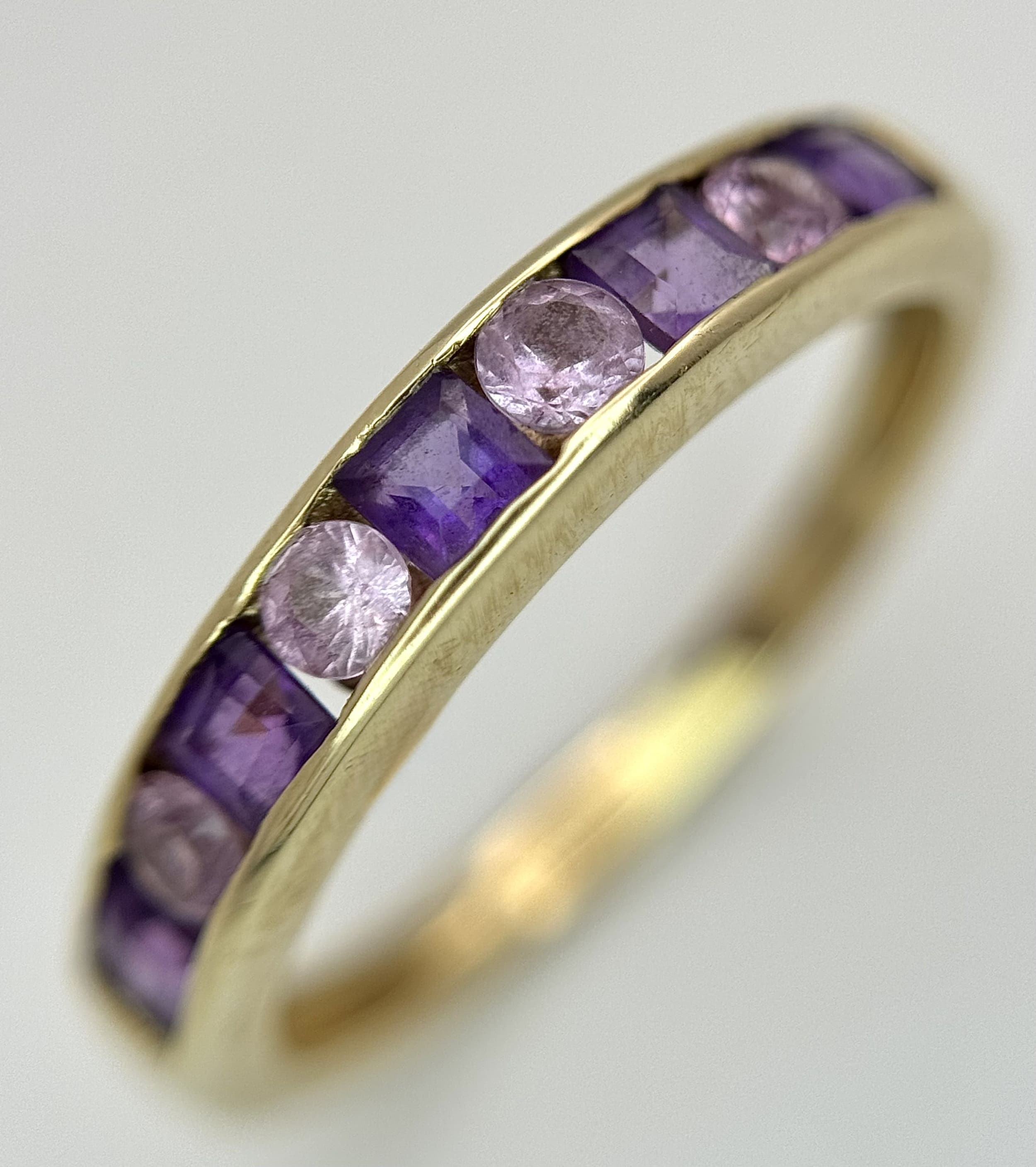 A 9K Yellow Gold Amethyst and White Stone Channel Set Ring. Size N 1/2. 2.05g total weight.