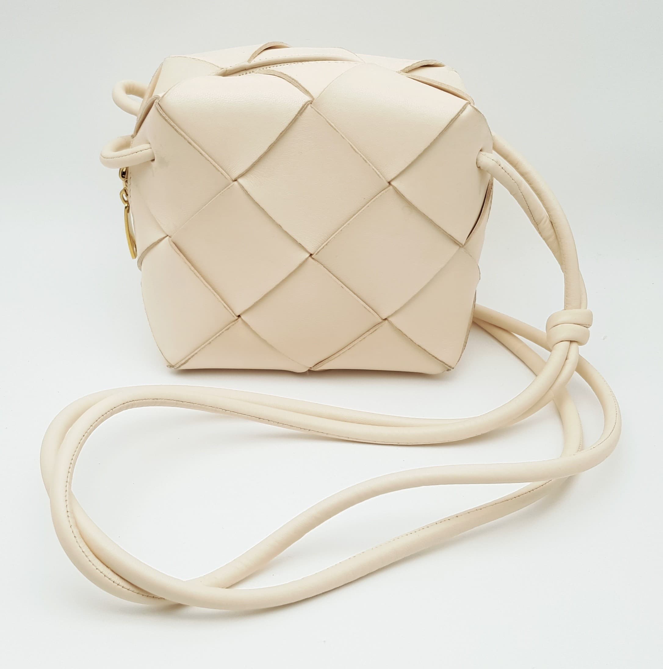 A Baby Pink Bottega Veneta Intrecciato Leather Mini Loop Camera Bag. Baby Pink woven leather exterior with gold-toned hardware, knotted shoulder strap and zipped closure. Approx 15cm length x 14cm height x 6cm depth. Comes with a certificate of authenticity, care booklet and dust cover. Some marks, stains and sign of wear to the leather. Please see photos or request a condition report. Ref: 28719.