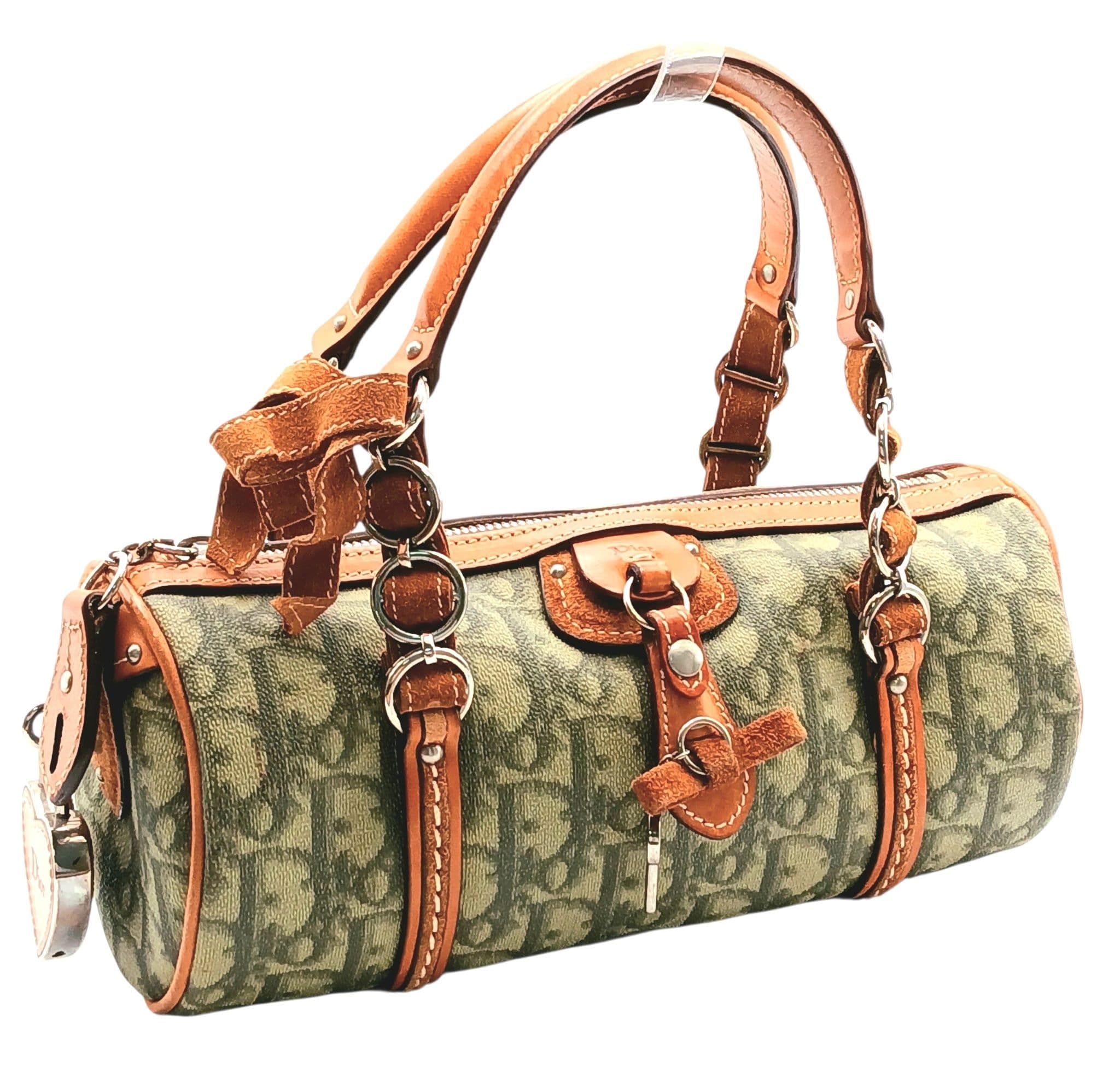 A Christian Dior Green Trotter Canvas Mini Boston Bag. Green Dior Trotter monogram canvas exterior with silver-toned hardware, dual rolled top handles, D charm/key detail, padlock and zipped top closure. Beige textile interior with one main compartment and a zipped side pocket. Approx 23cm length x 10cm height x 10cm depth. Some marks, scratches and signs of wear to the leather, some pen marks to interior. Comes with a certificate of authenticity. Please see photos or request a condition report. Ref: 28660.