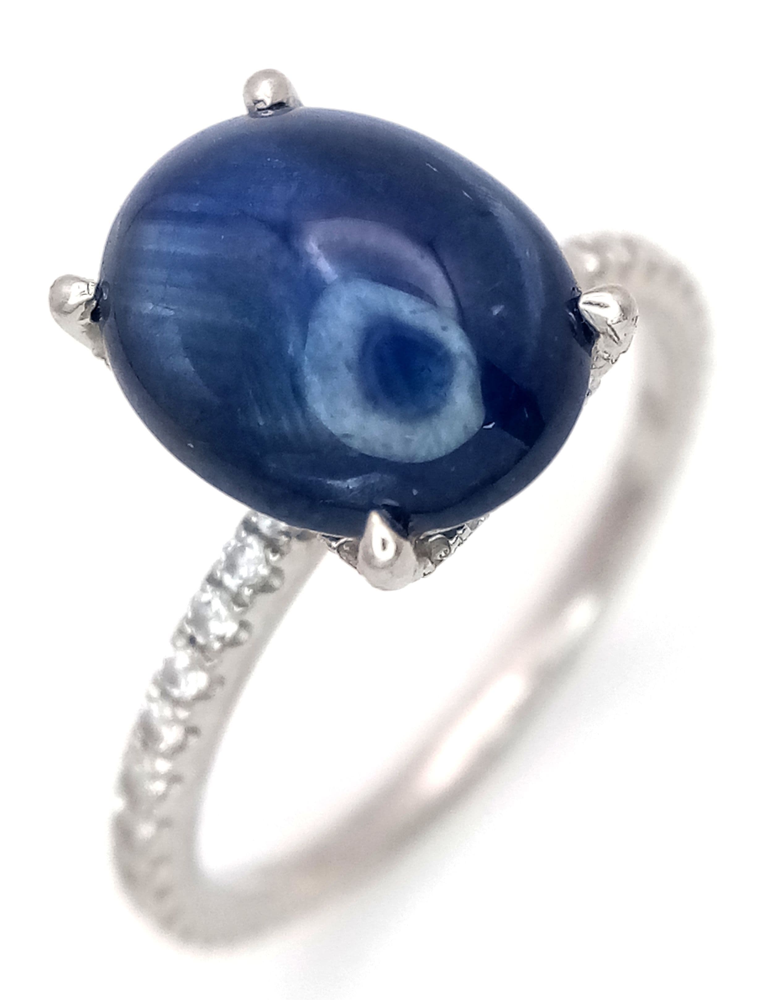 A Platinum and Sapphire Solitaire Ring. A 3.5ct sapphire cabochon with diamond accents on shoulders. Size N 1/2. 4.35g total weight. Ref: 4/61706.
