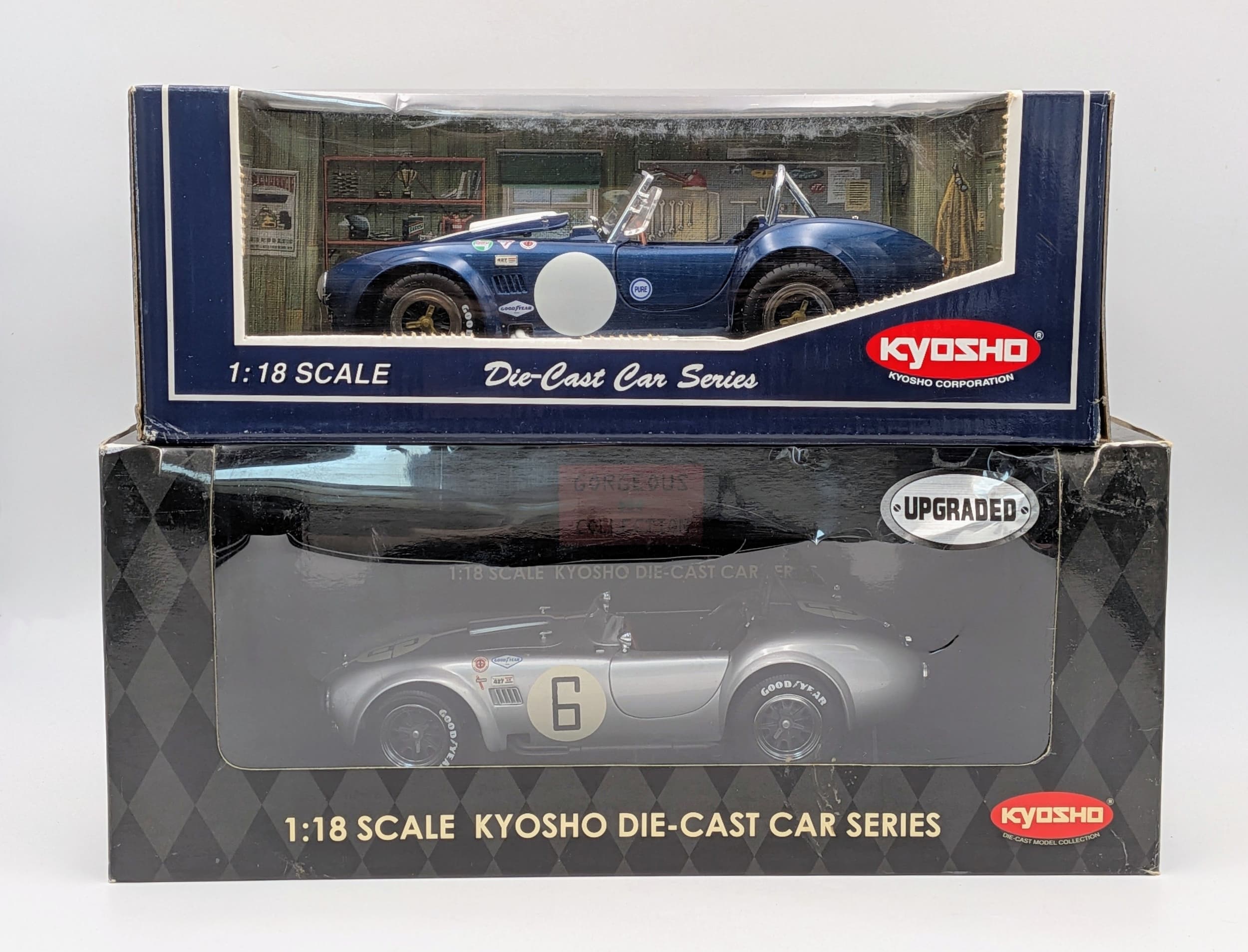 Two Kyosho, 1/18th scale diecast Shelby Cobra 427 models. In very good condition although one of the boxes shows signs of wear from storage.