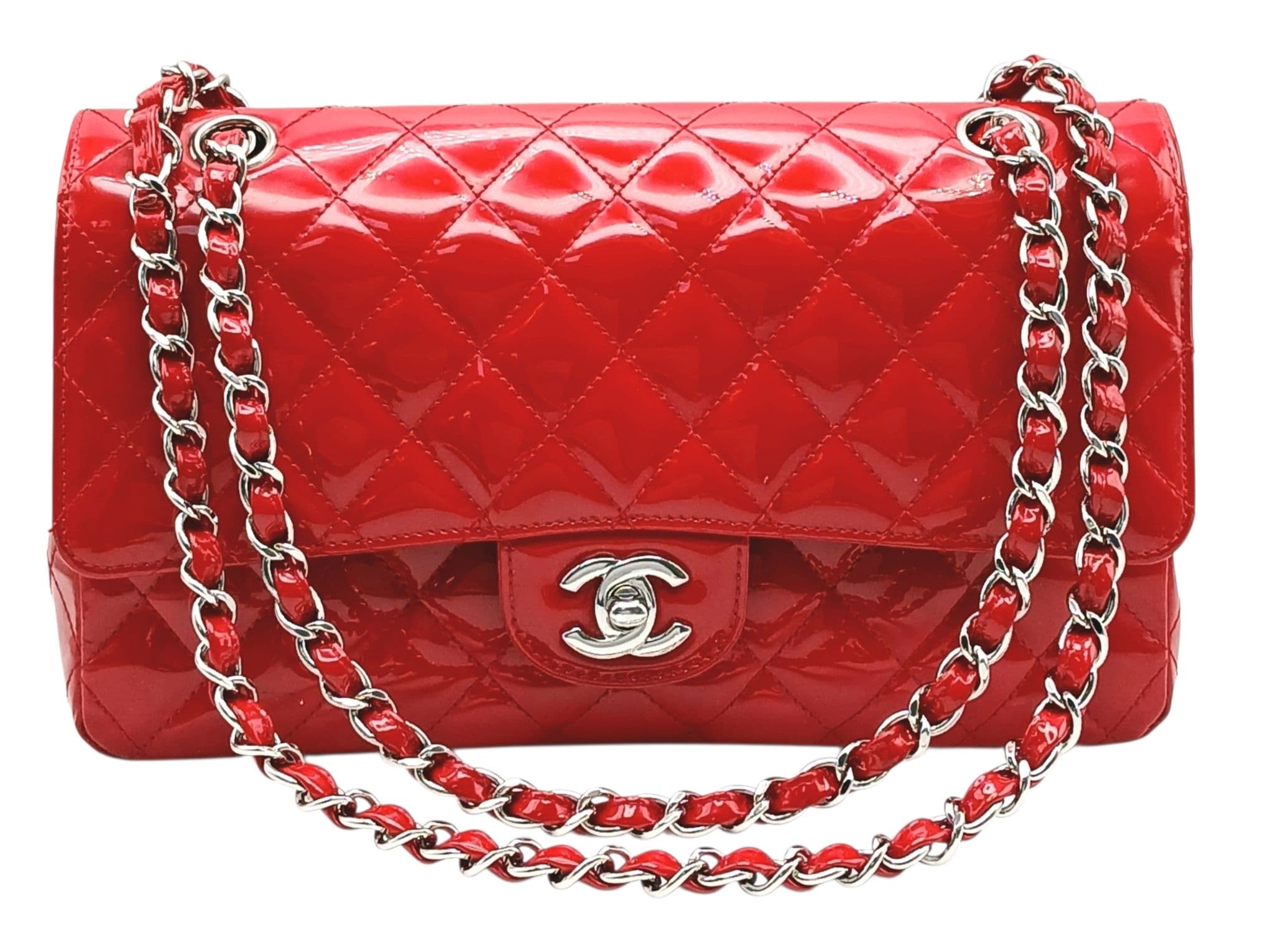 A Chanel Red Patent Leather Classic Double Flap Bag. Red leather exterior with silver-toned hardware, chain shoulder strap and CC turn-lock closure. Features one zipped pocket under the flap. Red leather interior with one main compartment, two open side pockets and a front pocket. Approx 25cm length x 15cm height x 6cm depth. Comes with a Chanel authenticity card and authentication paperwork. Some scratches, stains, signs of wear to the leather. Please see photos or request a condition report. Ref: 28726.