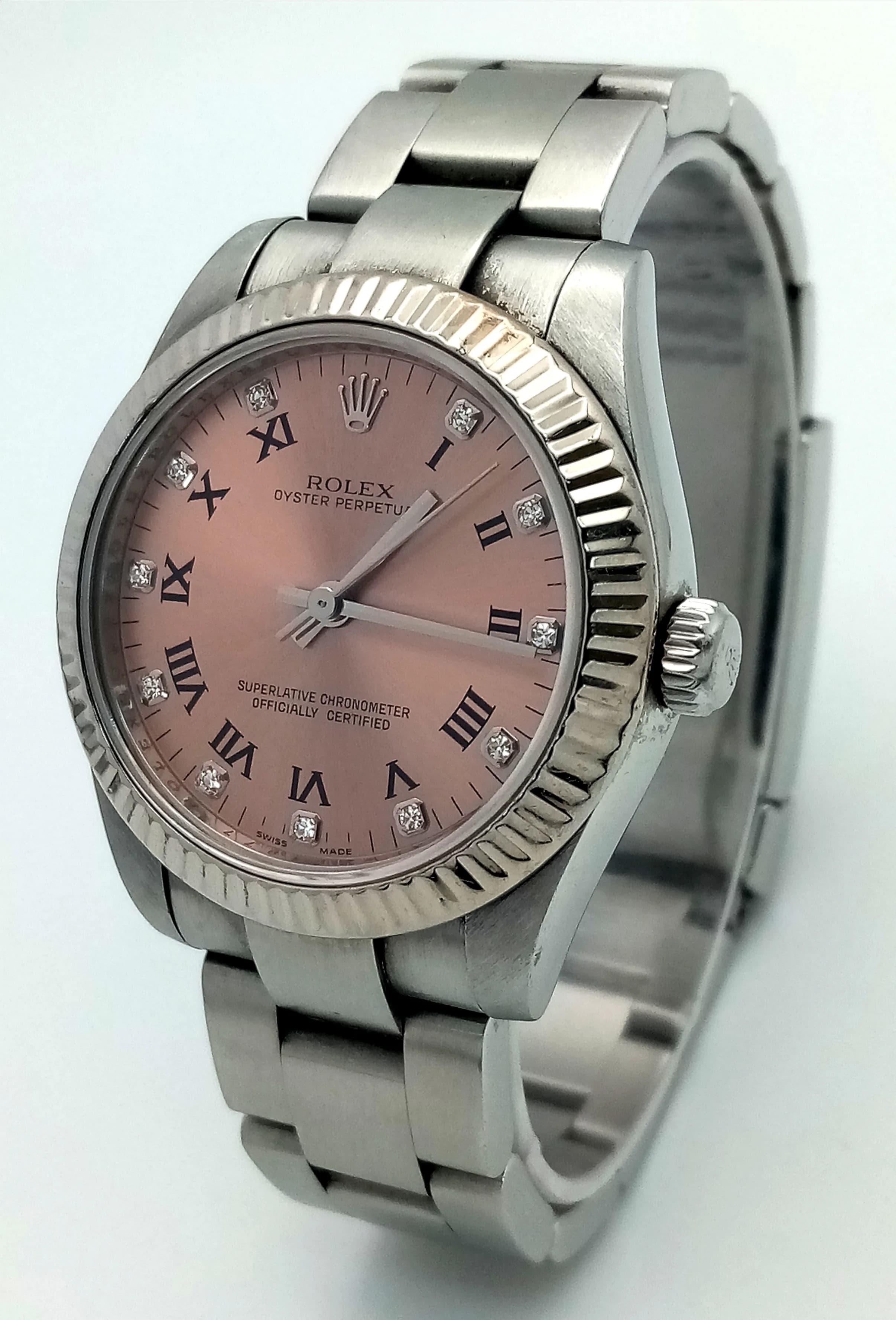 A Beautiful Rolex Oyster Perpetual Ladies Watch. Model 177234. Stainless steel bracelet and case - 32mm. Metallic salmon dial with diamond markers and Roman Numerals. In good condition and working order. Comes with case, spare links, and WCSA plus Watch register reports. Ref: 027963