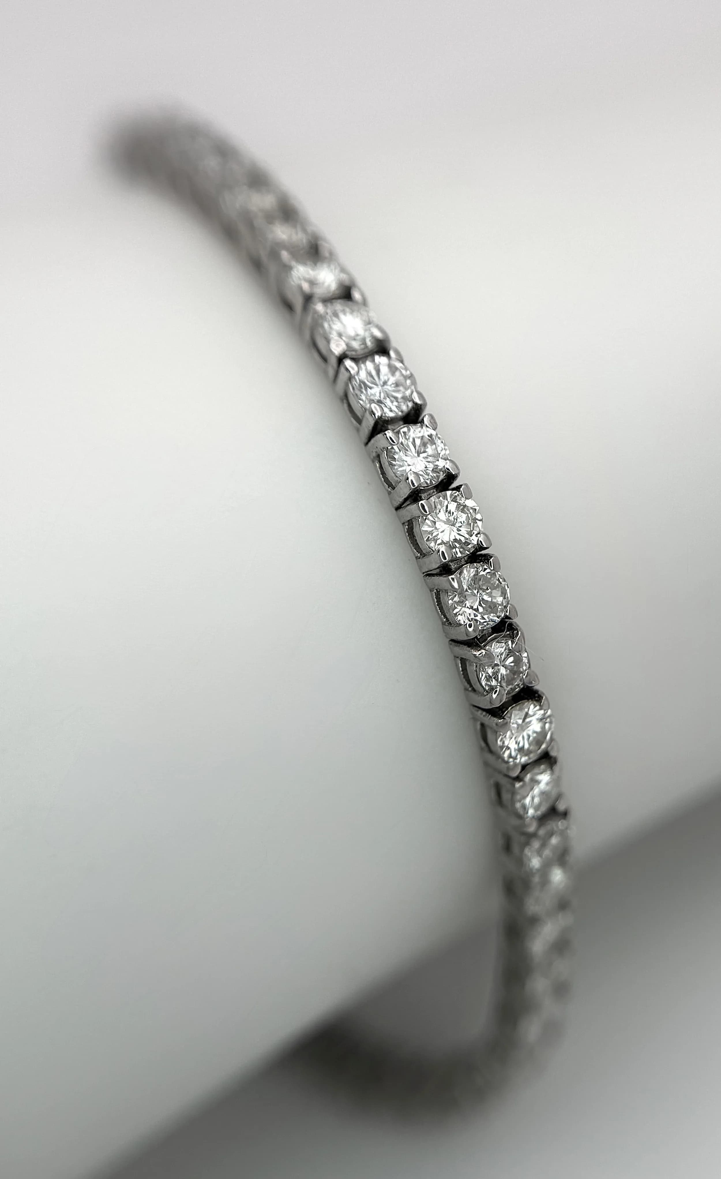 An 18K White Gold Diamond Tennis Bracelet. WGI certified. Set with 63 round brilliant cut natural diamonds, 4.90ctw, H colour, VS2 - SI1 clarity. 18.5cm length. 7.65g total weight. Ref: 8/611506
