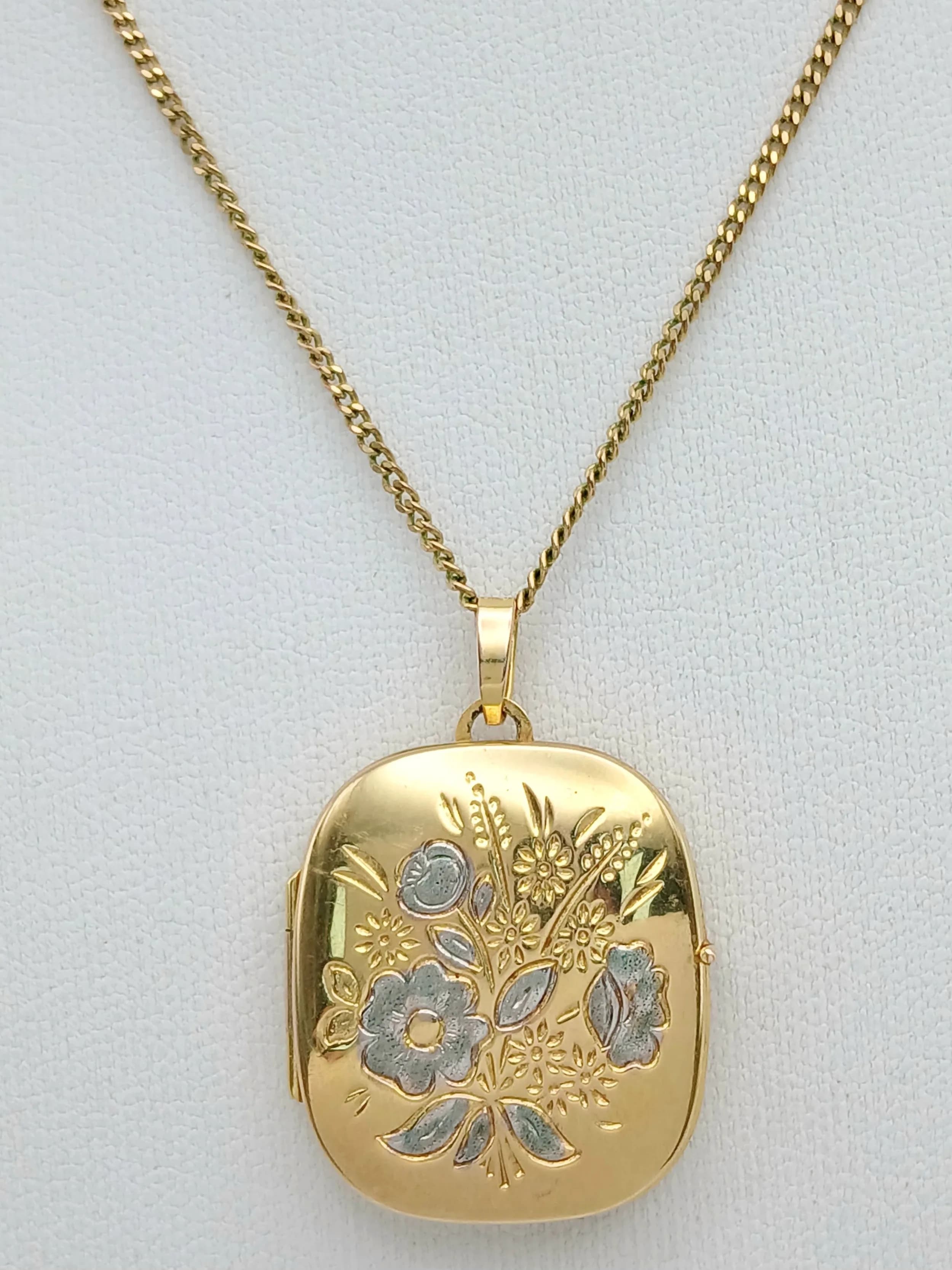 A 9K GOLD LOCKET PENDANT ON A 56cms 9K GOLD NECK CHAIN WITH NICELY DECORATED FRONT AND UNUSUAL SQUARE SHAPE . 6.6gms