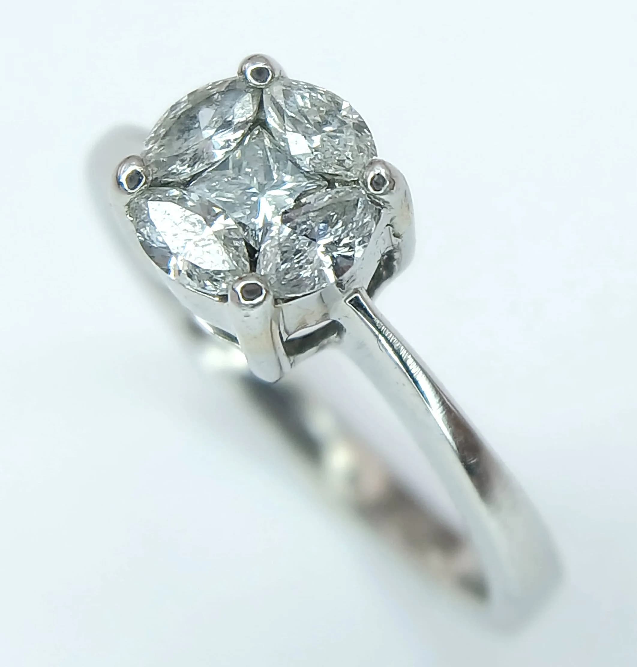 A Beautiful 18k White Gold Diamond Cluster Ring. Size K1/2. The Ring is set with a centre 4mm Princess Square Cut Diamond with Four 4 x 2mm Marquise Cut Diamonds surrounding, approximately 0.7 carat total. The Ringhas a gross weight of 3 grams. Comes in presentation box.