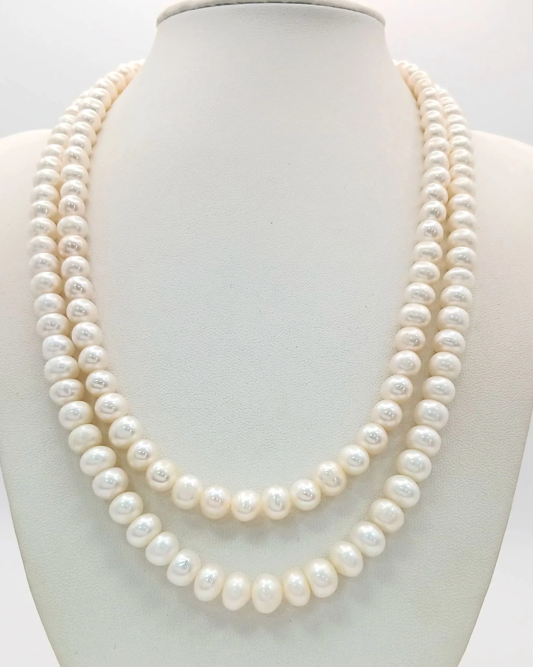 A Classic Double Strand Freshwater Pearl Necklace. Approx 46cm in length, strung with cream oval freshwater pearls and fitted with a decorative silver floral clasp set with a central pearl. Please see photos for details.