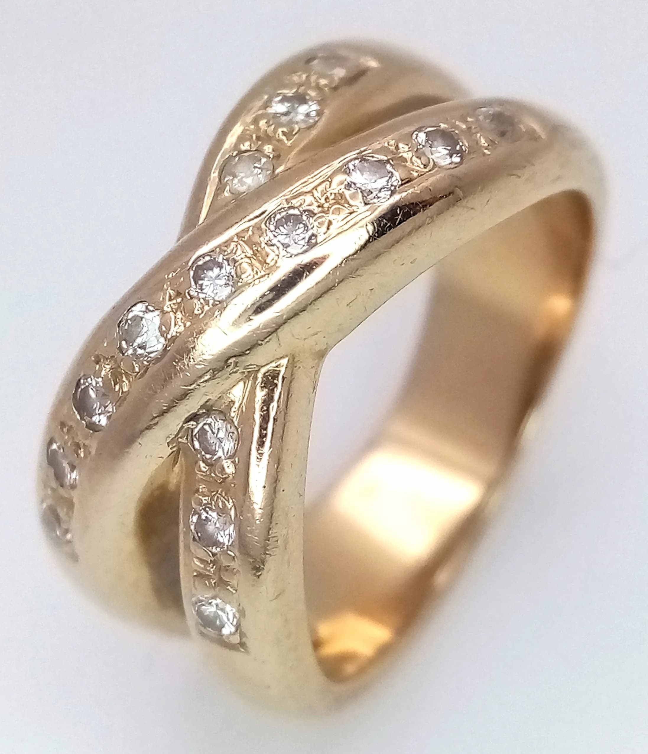 An 18K Yellow Gold (tests as) Diamond Crossover Ring. Wonderful diamond pave set criss-cross pattern. Size L 1/2. 8.62g.