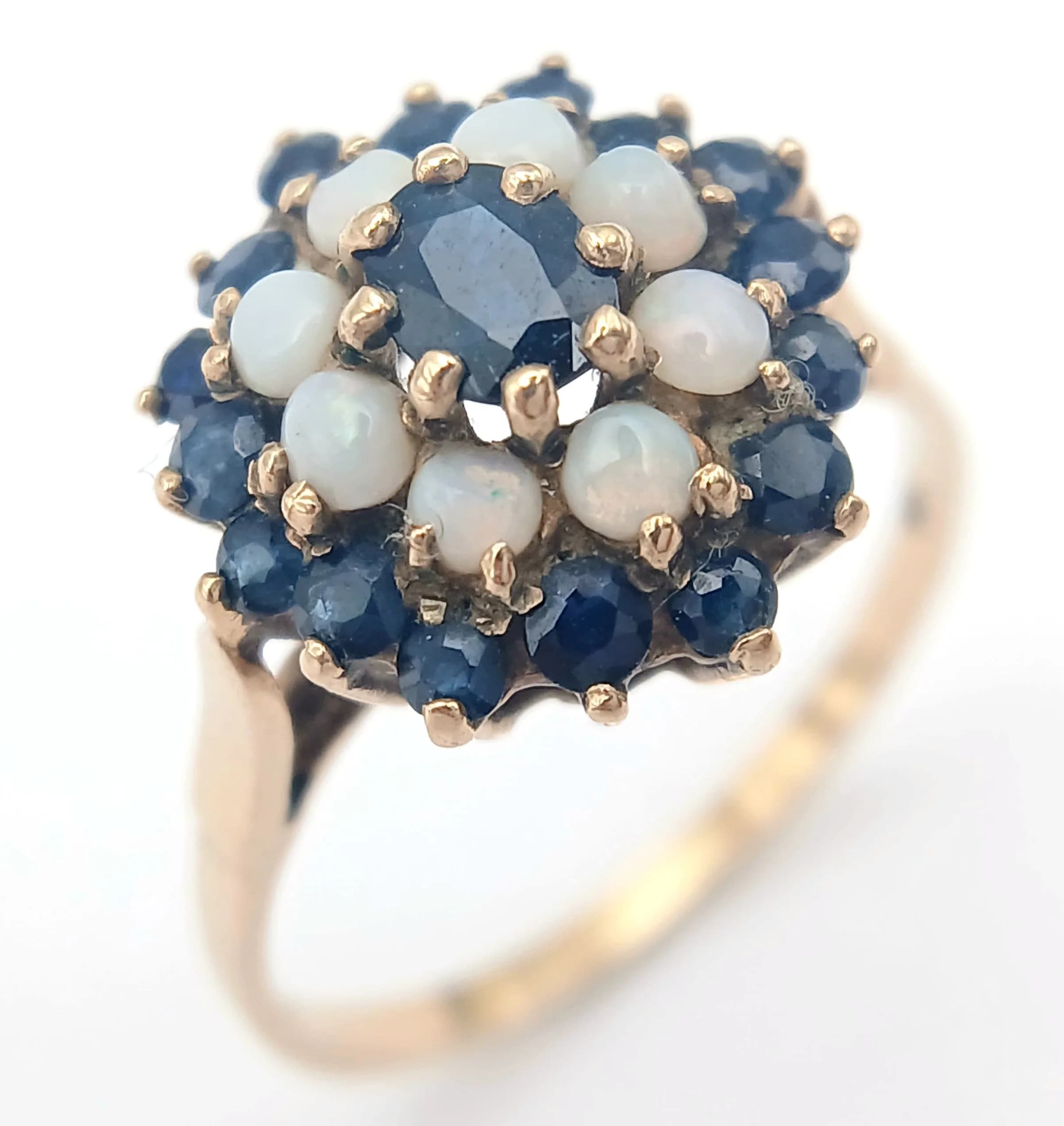 A 9K GOLD RING WITH A CLUSTER OF OPAL AND SAPPHIRES. 2.9fms size T