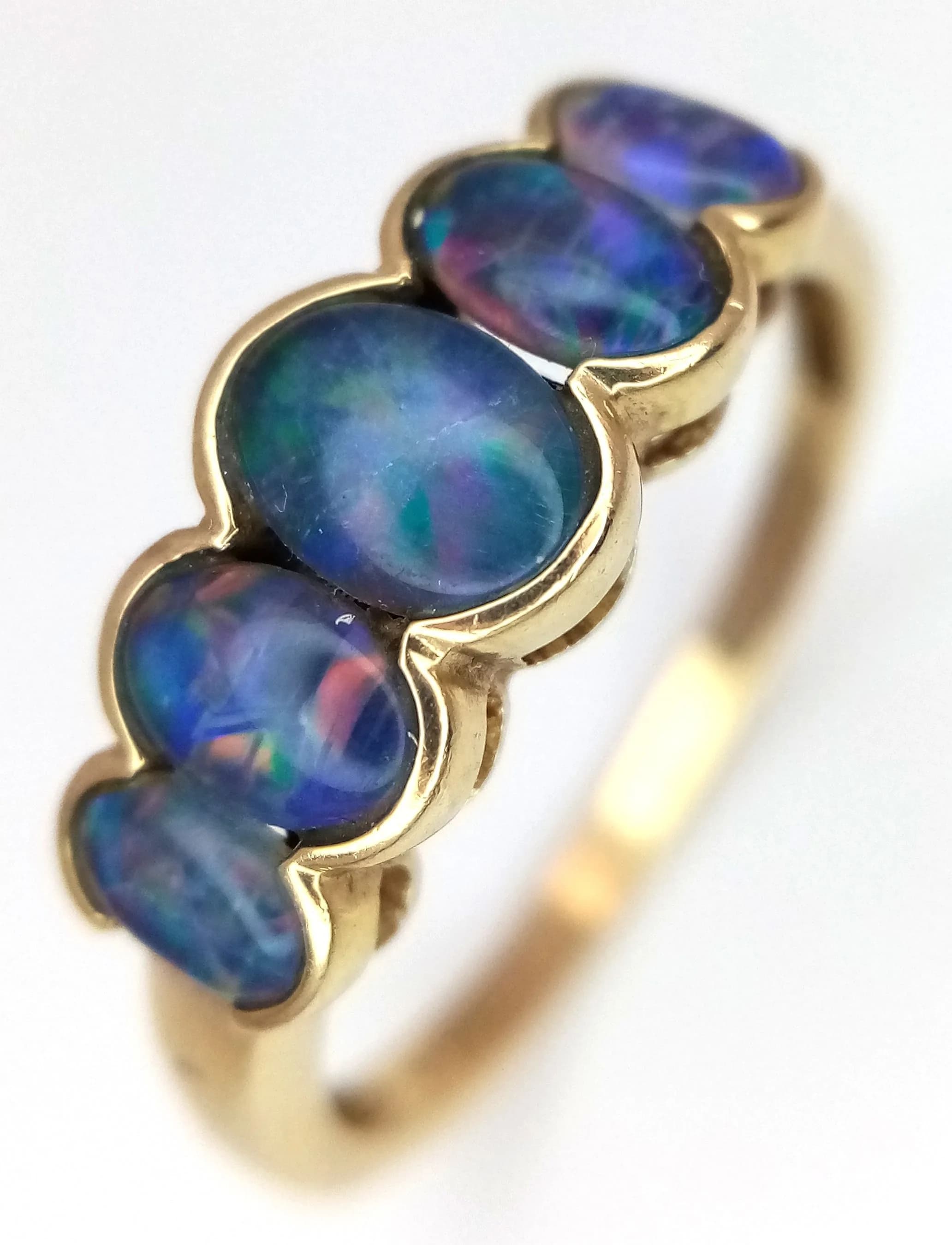 A Stylish Unisex 9k Yellow Gold and Five Opal Set Ring. Size V. The Ring is set with five graduating size Oval Cut Opals measuring from 4 to 7mm with a superb array of colours. The Ring has a gross weight of 2.7 grams.