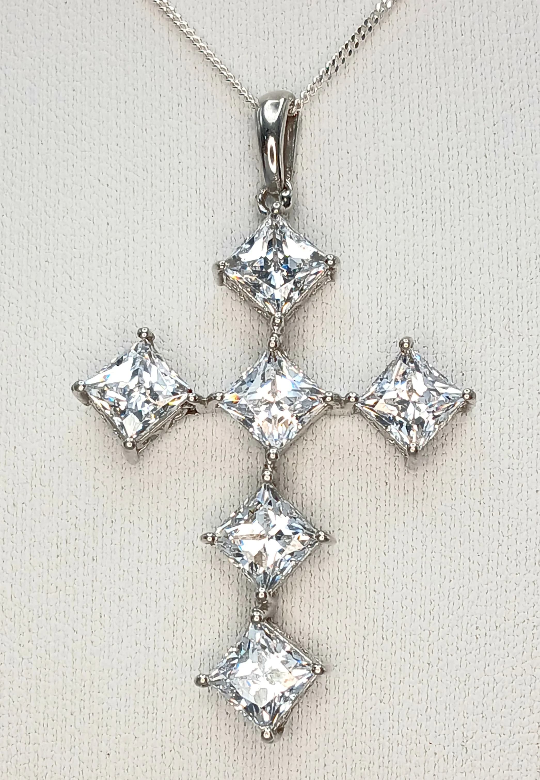 An Eye-Catching Sterling Silver Cubic Zirconia Cross Pendant Necklace- 41cm Length Chain. The Cross measures a 4.5cm Drop from the chain and the Necklace has a gross weight of 7.4 grams.