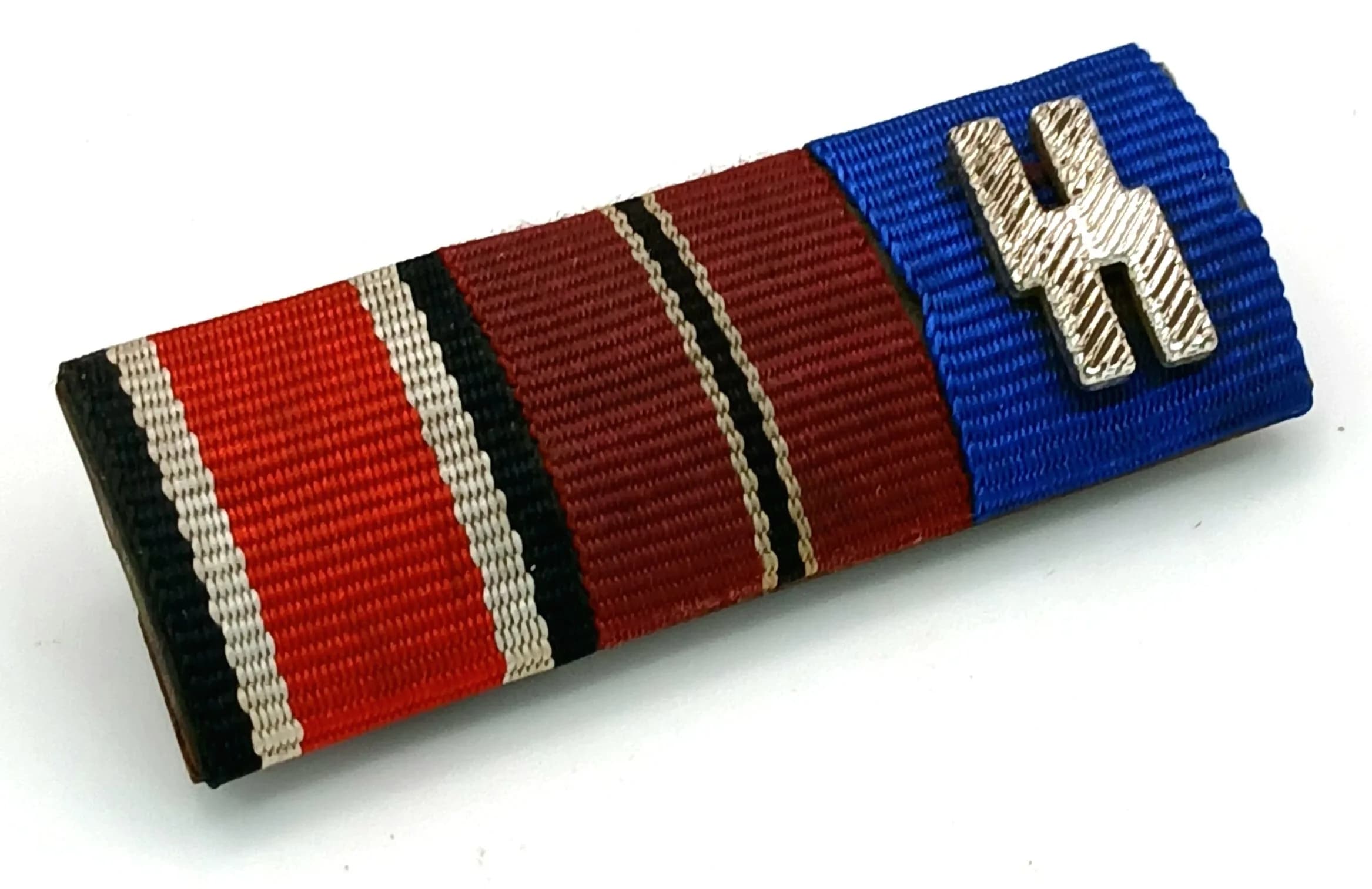 WW2 Waffen SS Miniature Ribbon Bar. The medals he received were the Iron Cross 2nd Class, The Eastern Front Medal and the SS 12 Year Service Medal. Please note this is just the ribbon bar and does not come with the medals.