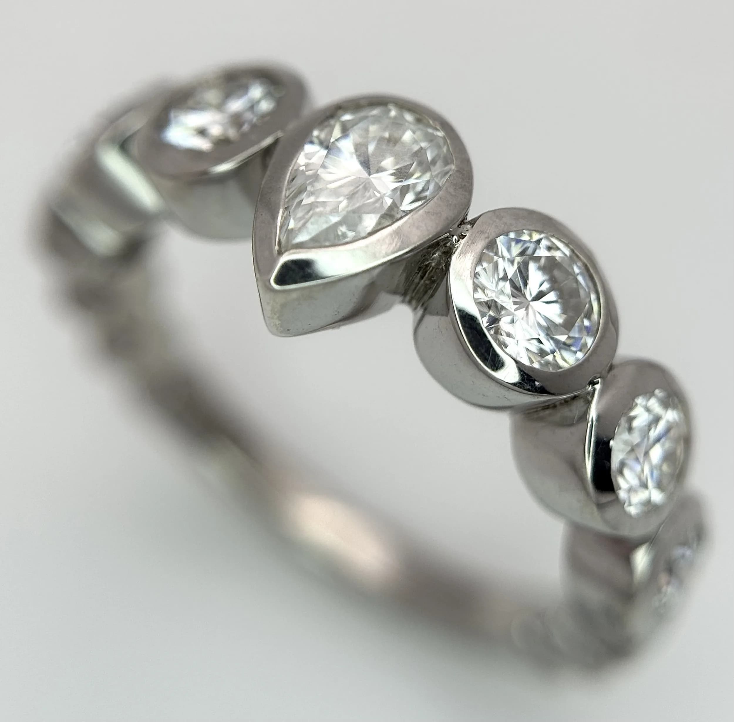 A Sterling Silver 1.4 carat Diamond Set Ring, Size O. The Ring is set with a 6x4mm Pear Cut Centre stone, with 2 x 4mm, 3mm and 2mm stones set beside. The Ring has a gross weight of 3.94 grams.