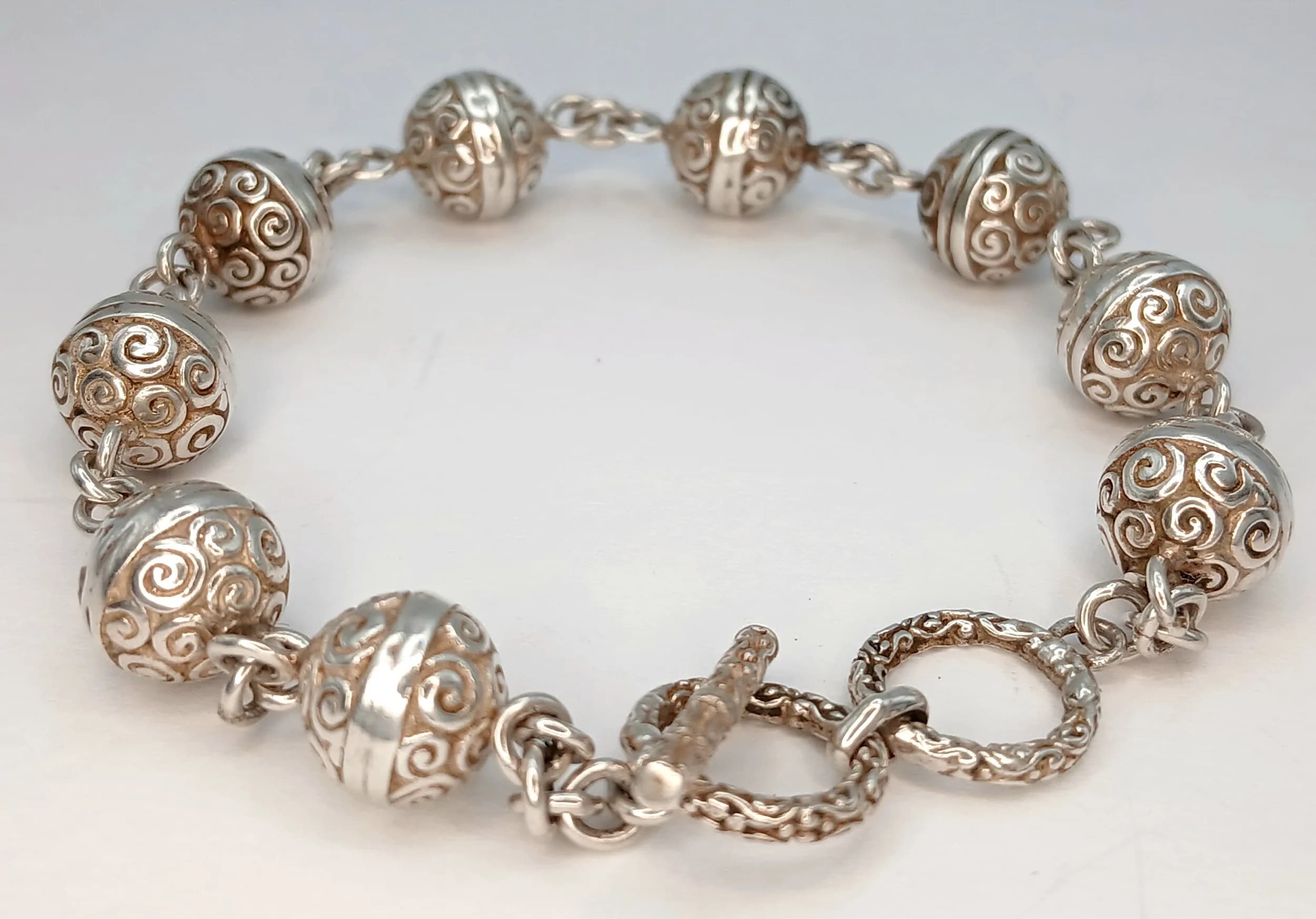 A Lovely Silver Decorative Bead Bracelet. Set with engraved round silver beads and chain link spacers, with toggle clasp fastening. Approx 18cm length. Total weight 18.30 grams.