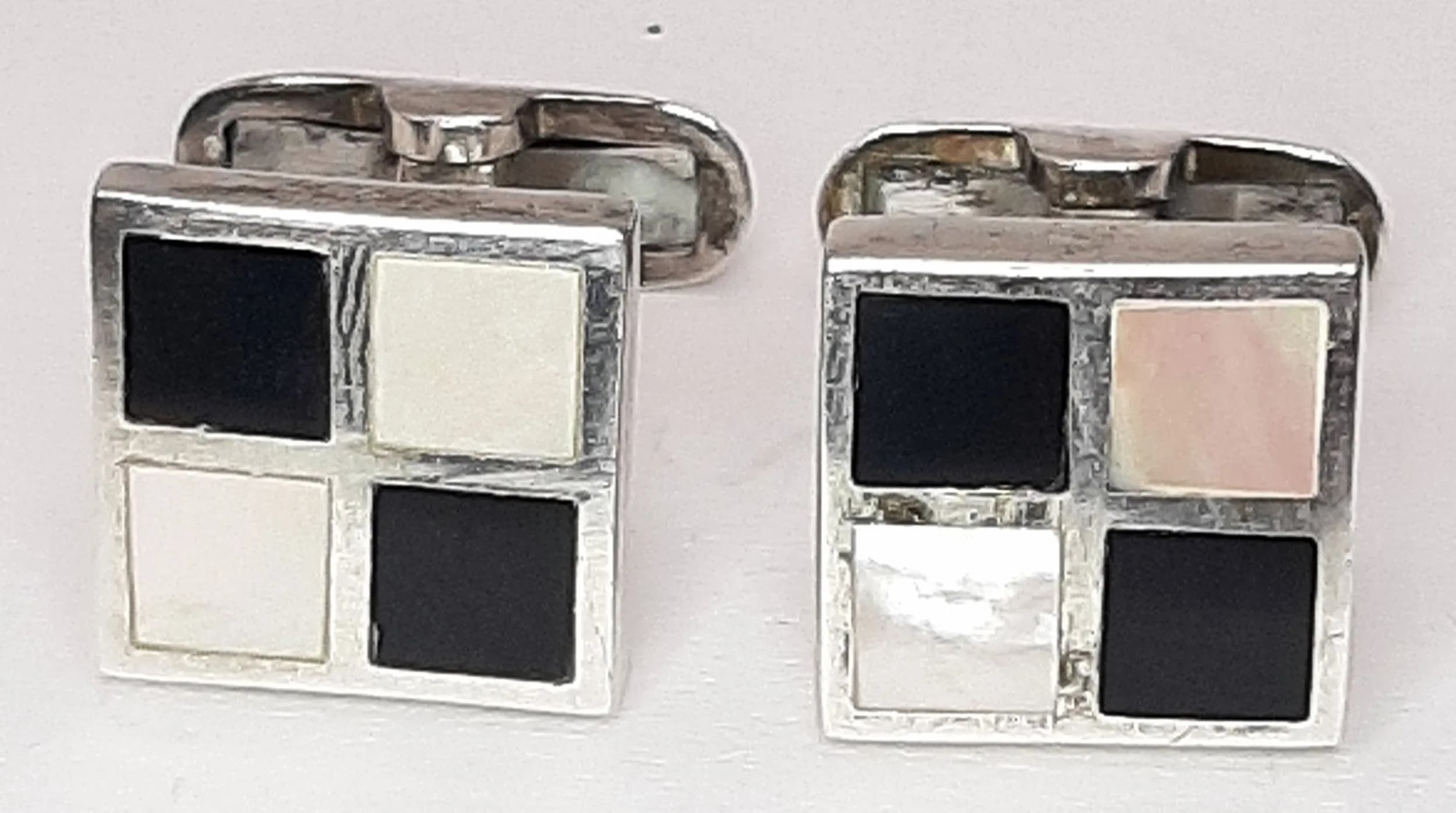 A Lovely Pair of 925 Silver Mother of Pearl and Black Onyx Cufflinks. Each square cufflink set with mother of pearl and black onyx checkerboard inlay. Approx 1.3cm x 1.3cm. Total weight 10.67 grams. Comes with a presentation box.