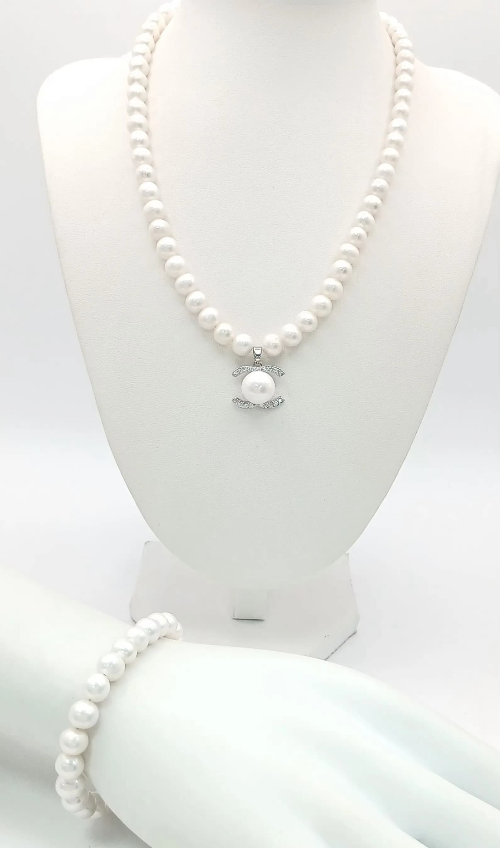 An elegant Freshwater Pearl Necklace and Bracelet Set. The Necklace measures approx 42cm in length, strung with cream freshwater pearls, featuring a CC pearl and clear stone set pendant. The matching Bracelet measures approx 16.5cm in length. Please see photos for details.