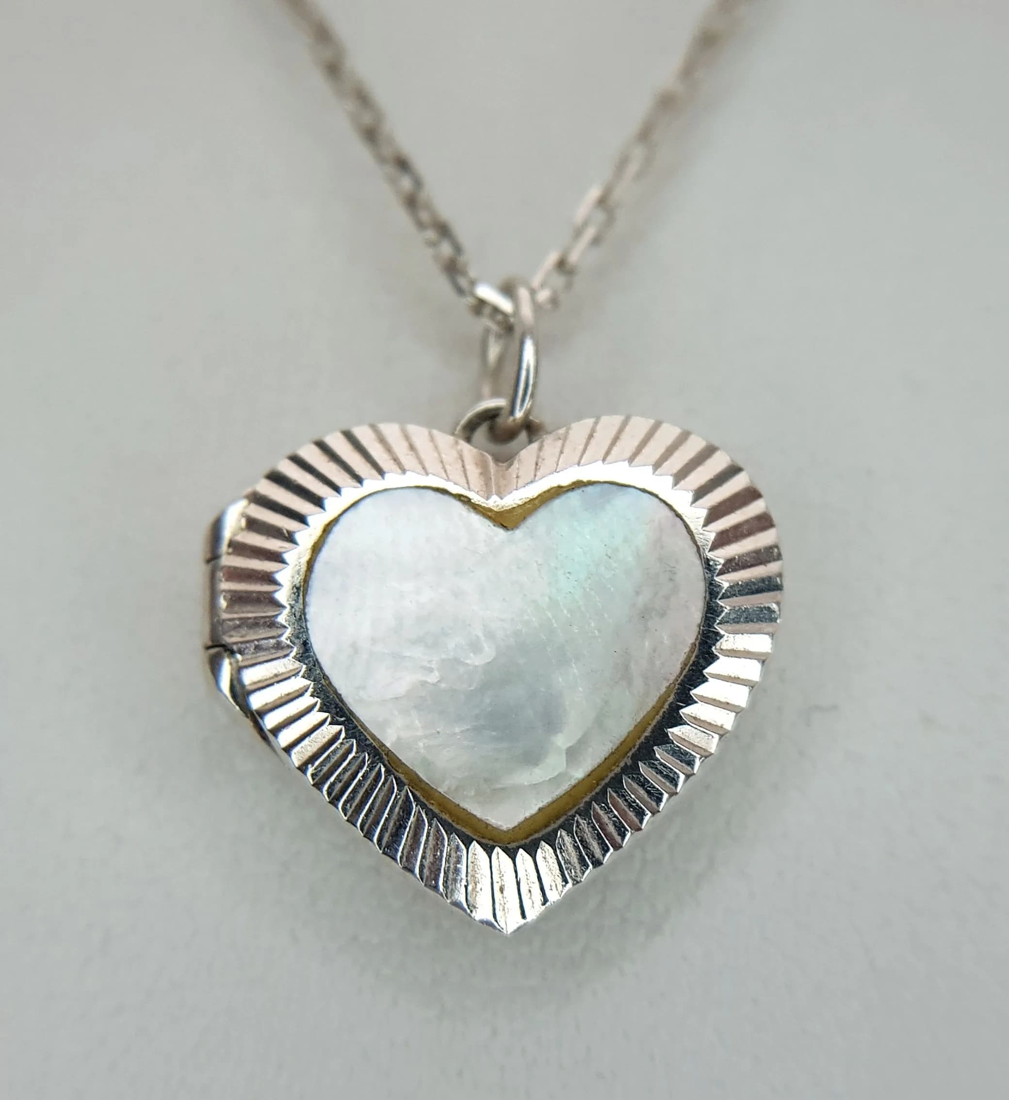 A STERLING SILVER, MOTHER OF PEARL SET, HEART LOCKET ON CHAIN. 21". 5.6G. SC 5142