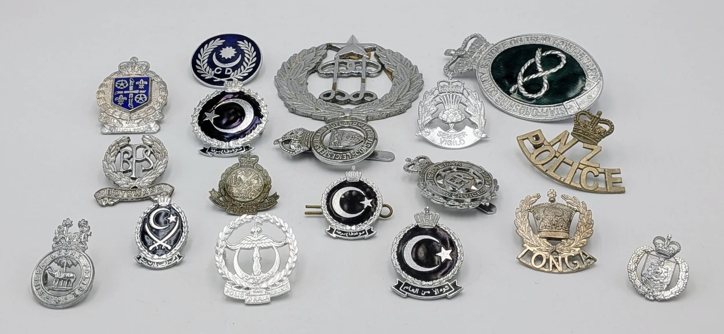 A collection of 18 Worldwide Police Cap Badges