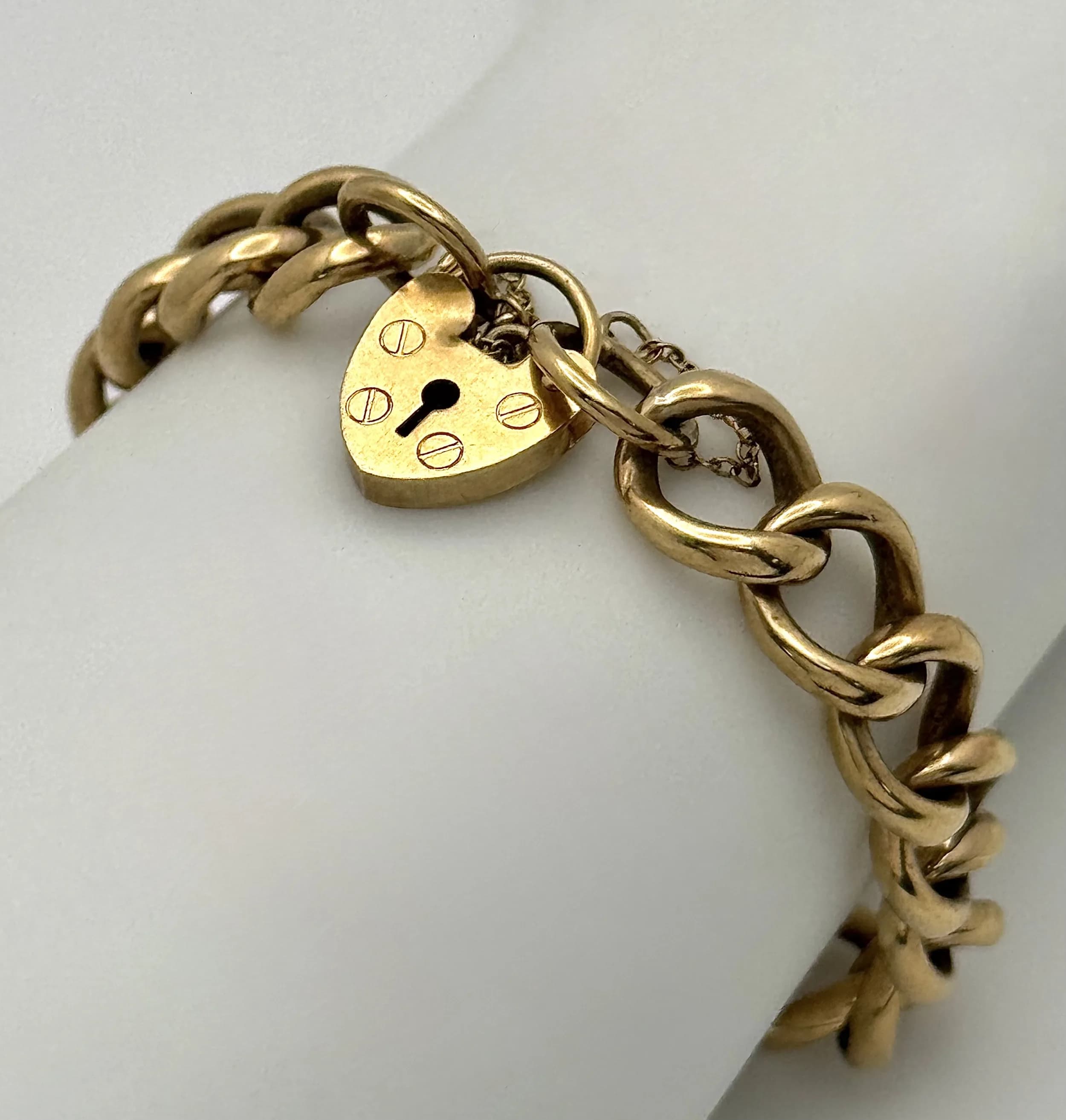 A Vintage 9K Yellow Gold Curb Link Bracelet with Heart Clasp and safety chain. 18cm. 16.57cm.