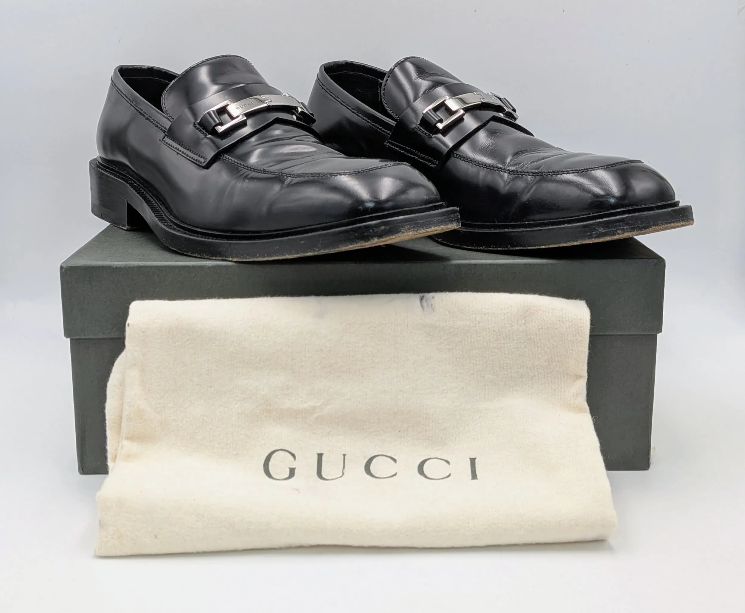 A Pair of Stylish Gucci Black Leather Gents Shoes. Size 42 1/2 E. Worn on soles but still in good condition overall. Comes with original packaging.