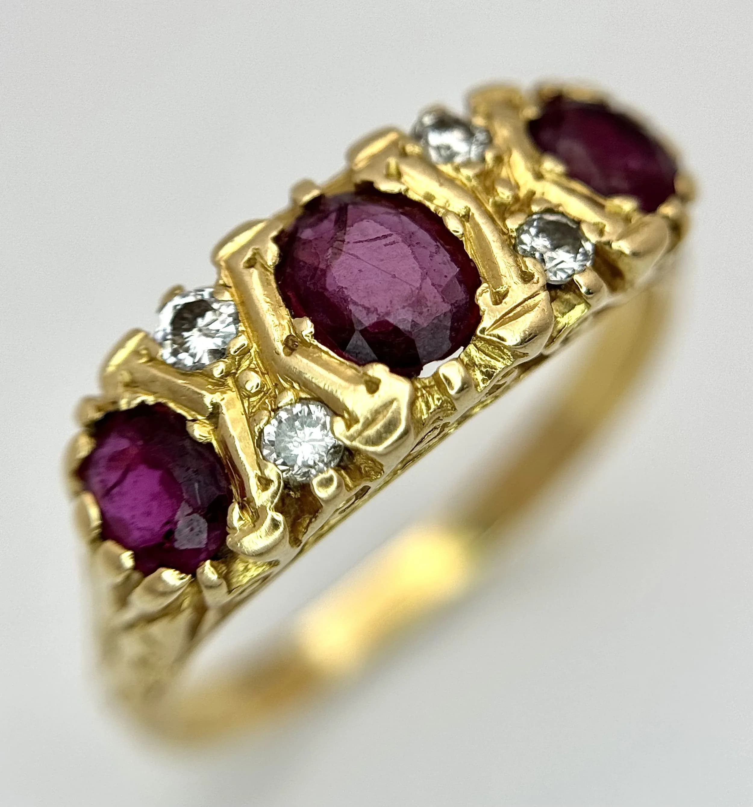 AN 18K GOLD 3 STONE GYPSY STYLE RING WITH LARGE RUBY STONES SEPERATED BY 4 DIAMONDS . 5.8gms size S