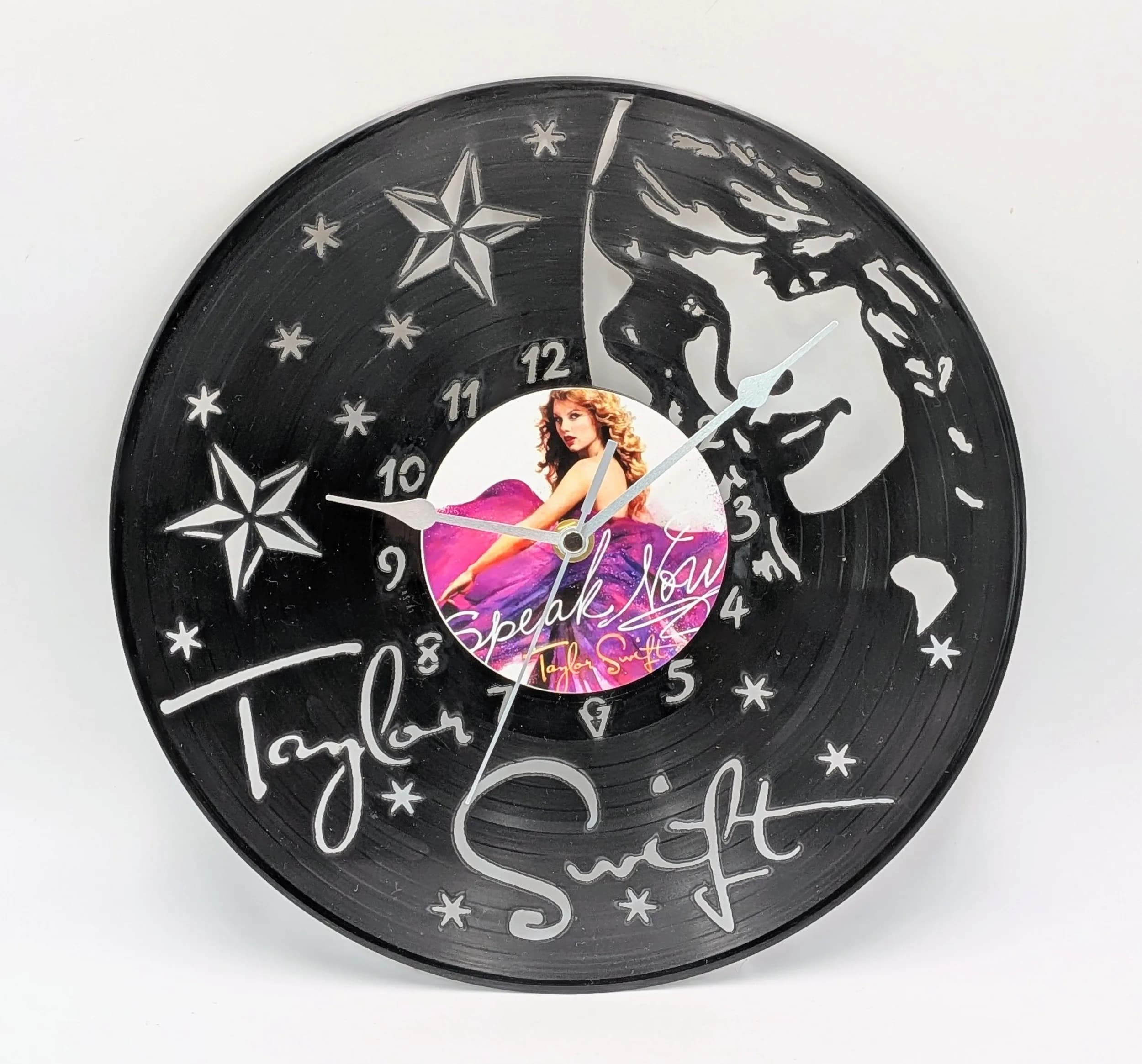 A Taylor Swift Custom Made Wall Clock. Laser-cut used vinyl creates the iconic Speak Now Album image. LP sticker to centre with noiseless sweeping hand battery movement. 30cm diameter. Needs one AA battery. Comes with box.