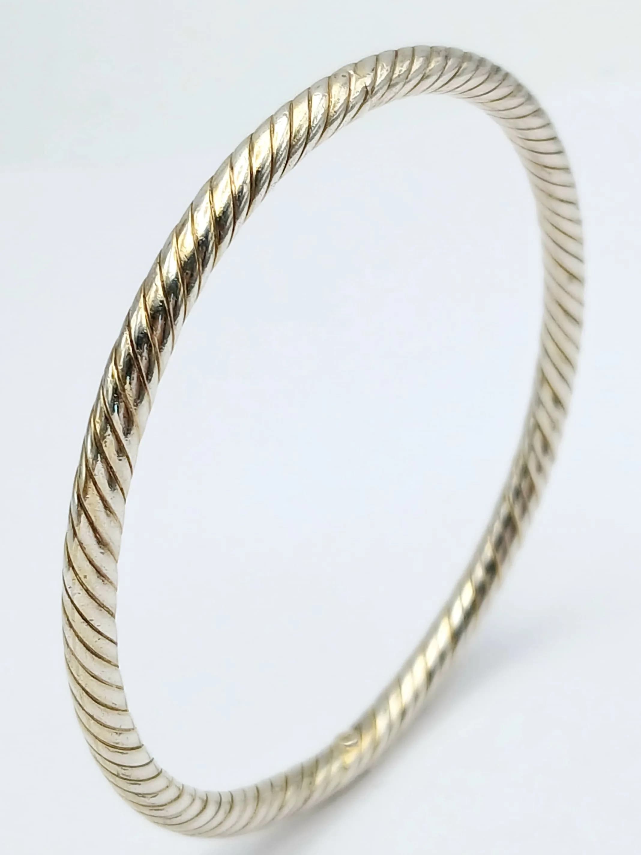 A Pretty 925 Silver Rope Twist Bangle. Featuring a circular twisted rope design. Approx 7cm diameter. Total weight 10.03 grams.