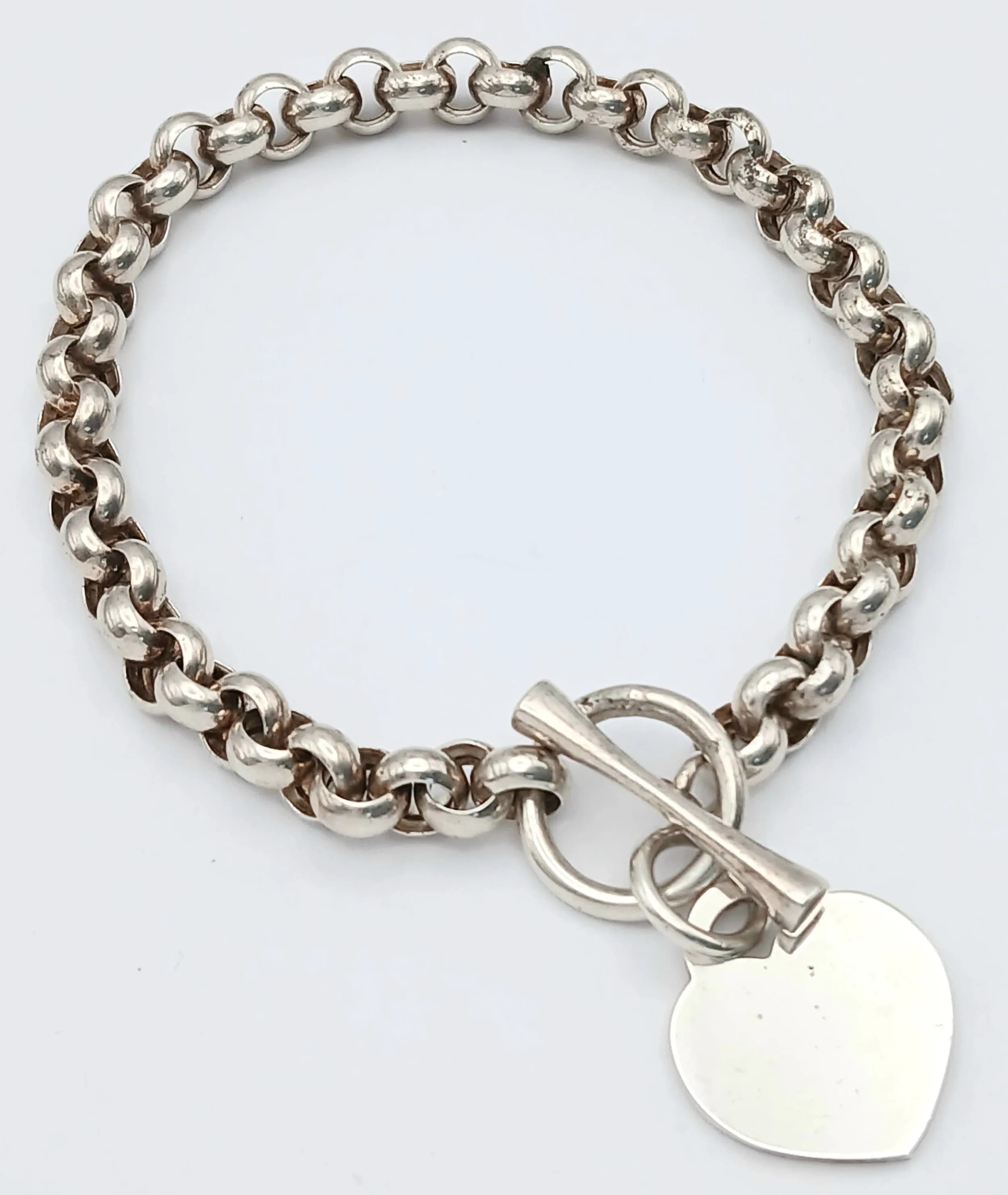 A Lovely Silver Heart Padlock Bracelet. Featuring a silver link chain with heart padlock charm and toggle clasp fastening. Approx 17cm length. Heart charm approx 2cm x 2cm. Total weight 13.37 grams.
