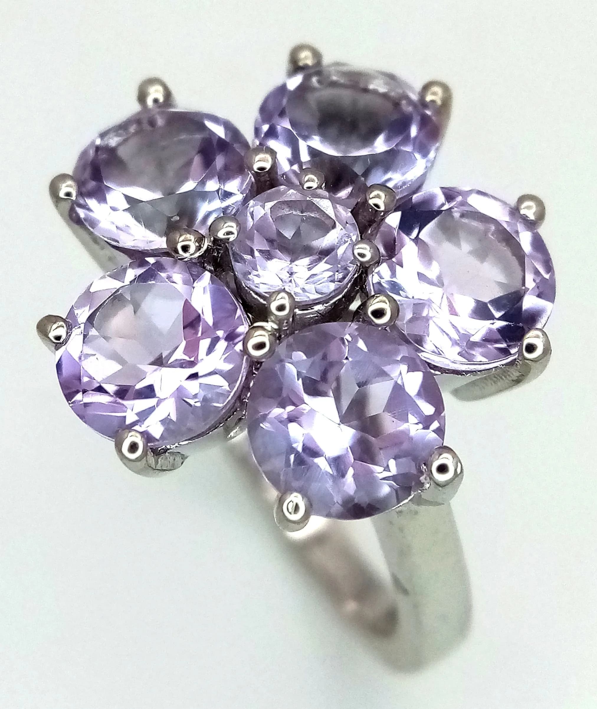 A Pretty Platinum Bonded Amethyst Set Cluster Ring. Size N1/2. The Ring measures 1.7cm diameter at the Crown and has a gross weight of 4.26 grams.