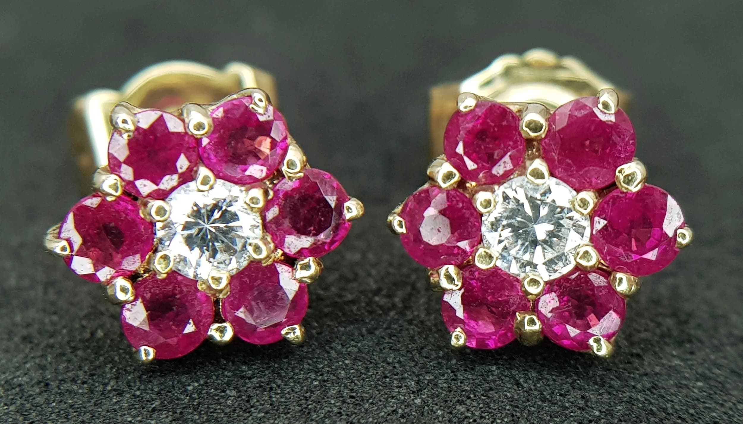 A Pair of 18K Gold Ruby and Diamond Stud Earrings. Centre diamond with ruby surround. 2.4g total weight. MT37.