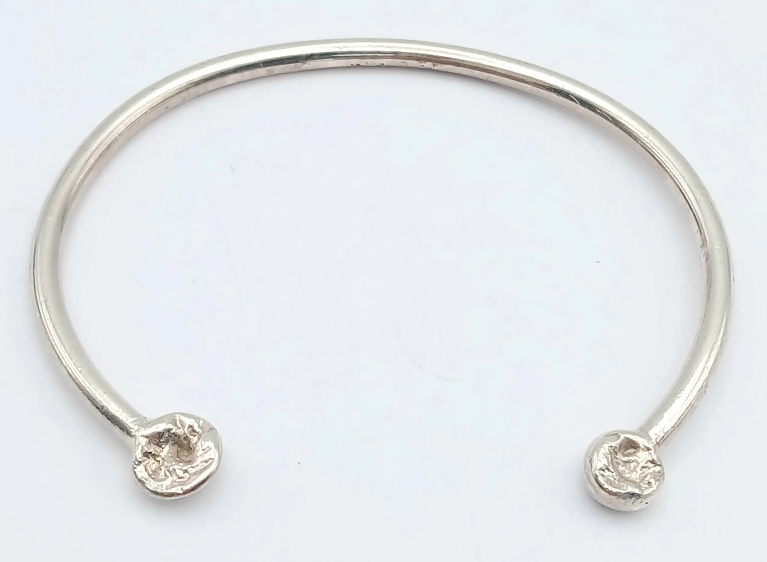 A Ladies or Childs Sterling Silver ‘Nugget’ End Torque Bracelet. 5cm inner width. The Bracelet weighs 6.39 grams.