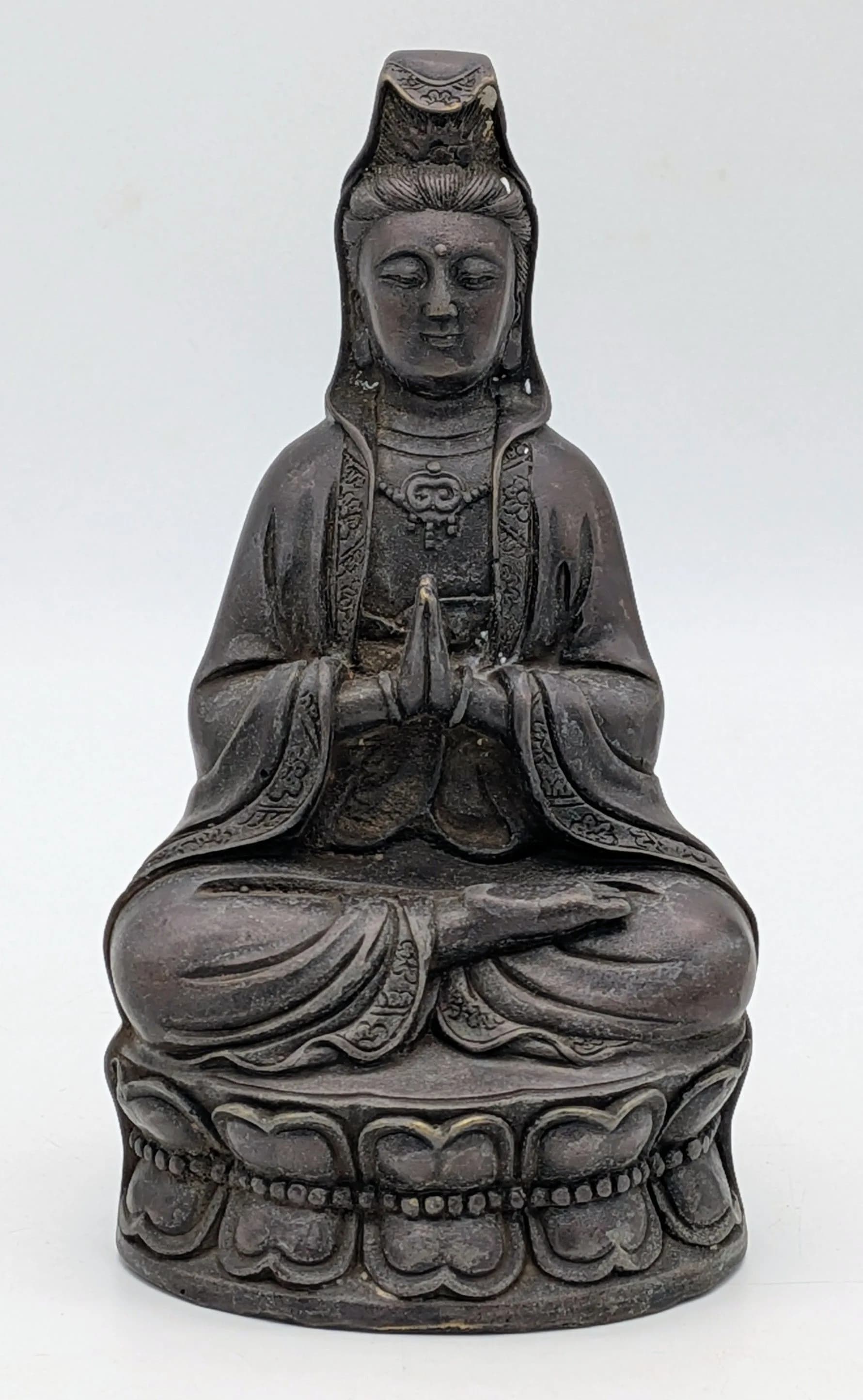 An antique Asian Bronze Seated Guanyin Buddha Figurine, featuring detailing in robes, facial expression, and hair; cast bronze construction. Marking on base. Exhibits signs of wear, oxidation, and patina consistent with age; no visible cracks or repairs. Approximately 18cm height x 9cm width.