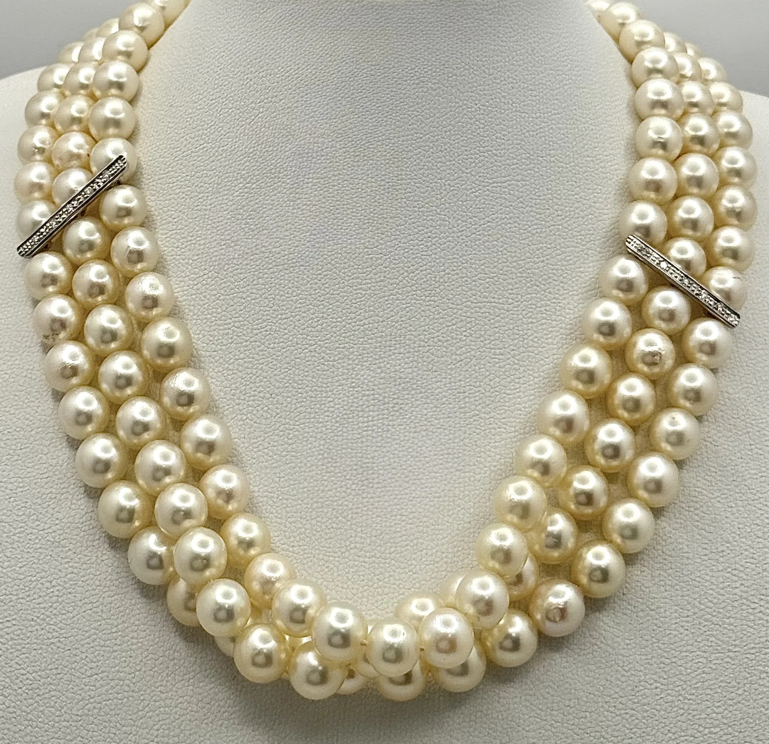 A Head-Turning Three Row Cultured Pearl Choker Necklace -with an Art Deco Style 18K White Gold and Diamond Encrusted Clasp of 27 x 16mm. Diamond and gold bar spacers complete this wonderful necklace. 34-36cm. 86.3g total weight. MK04