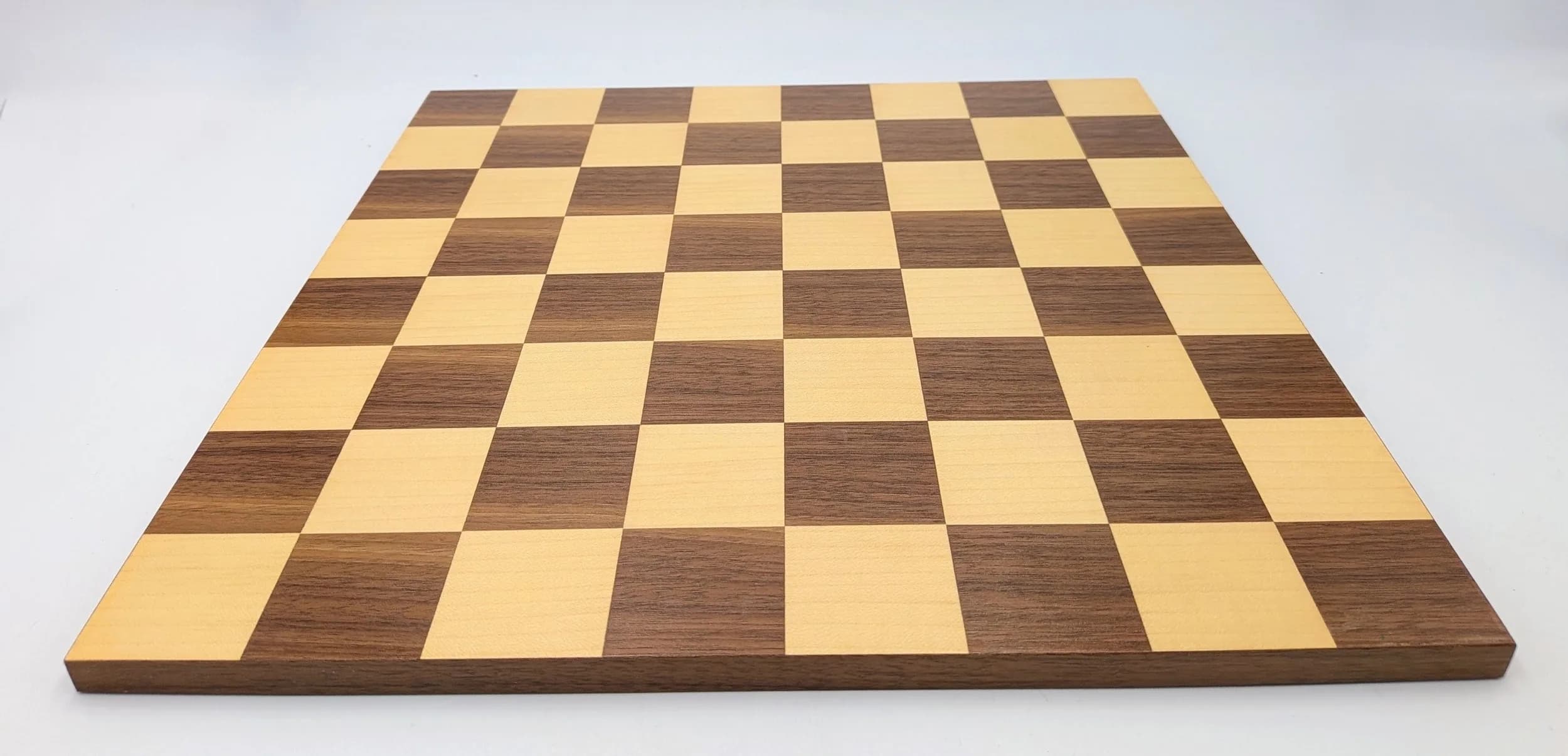 A Walnut and Sycamore Chess Board. Veneer inlaid with alternating walnut and sycamore squares. Approx 43mm squares.