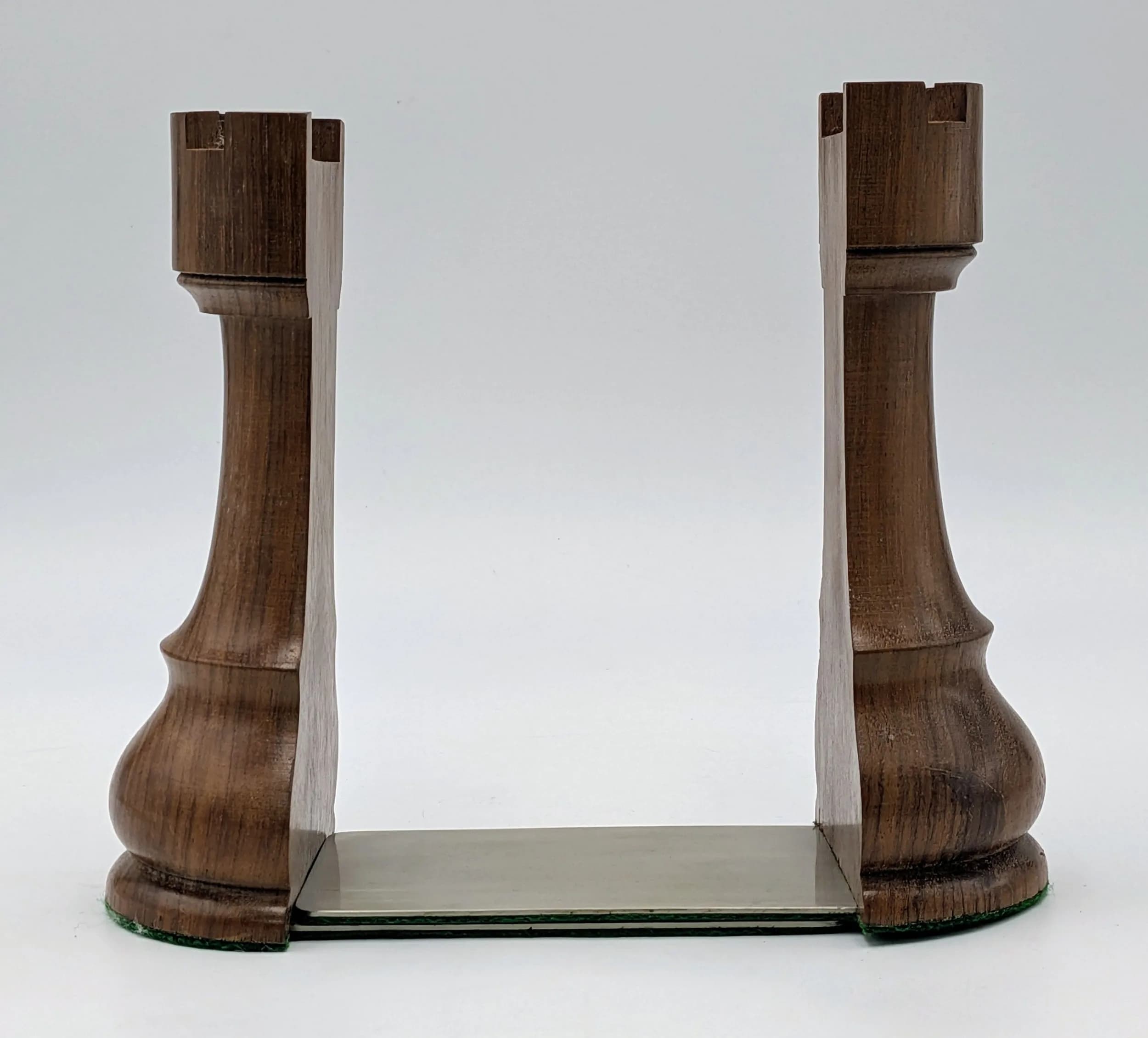 A Pair of Wooden Rook Bookends. Modelled as chess rook pieces with metal bookend supports. Approx 15.5cm height.
