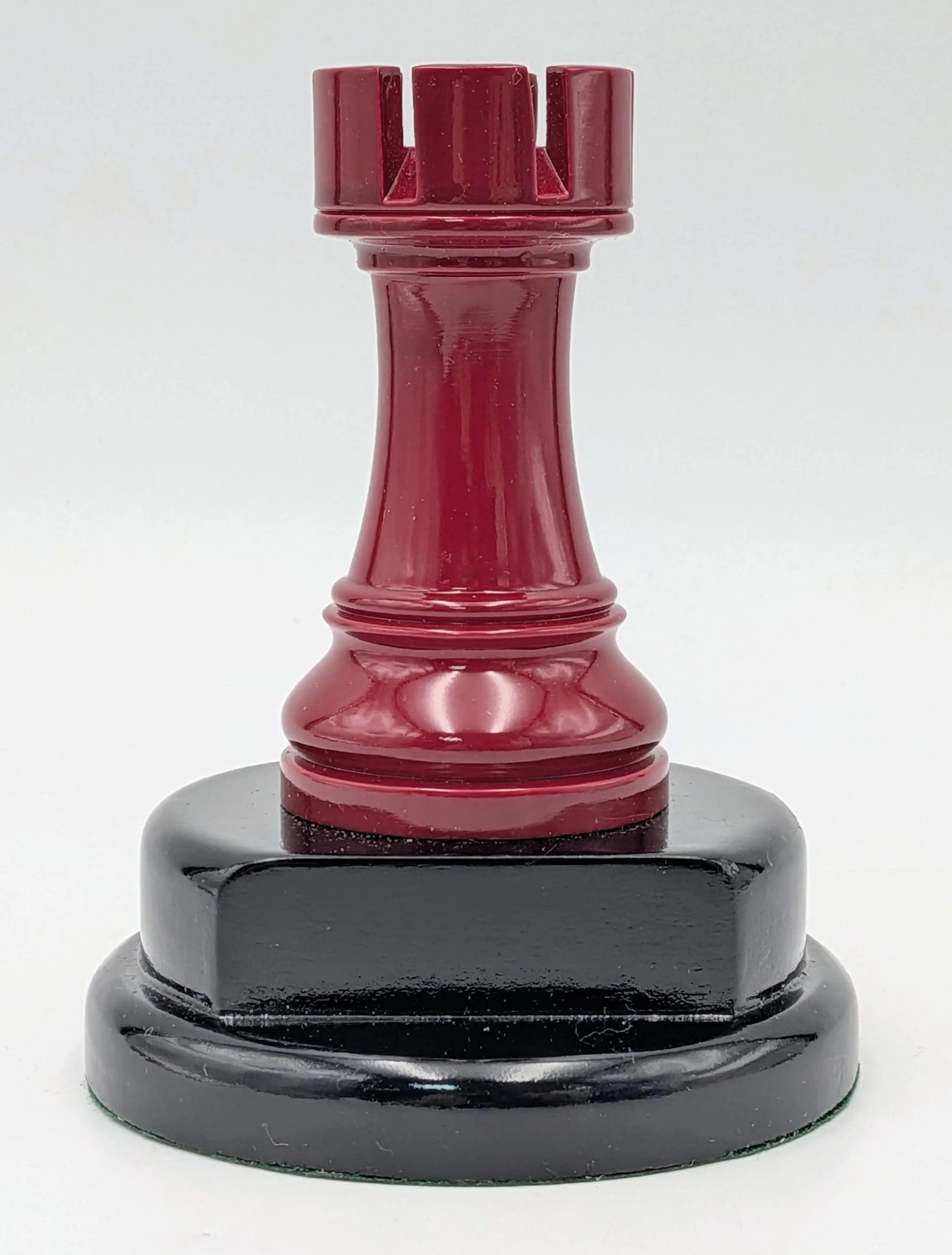 A Red Rook Trophy. Modelled as a red chess rook piece on a black plinth base. Approx 11.5cm height.
